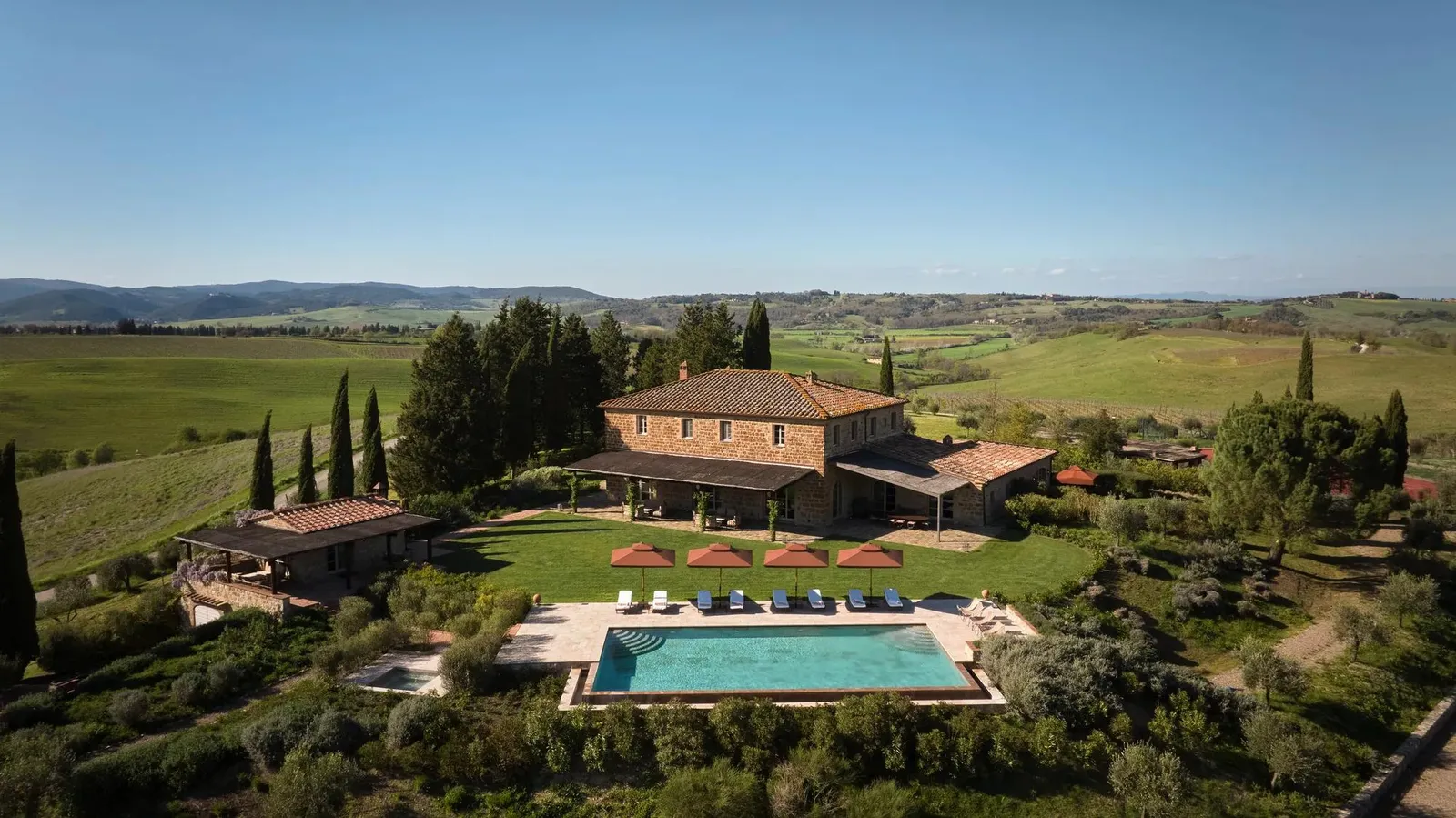Villa Oddi from above, among the fields: the 2 stone houses, the pool and the country to the horizon.