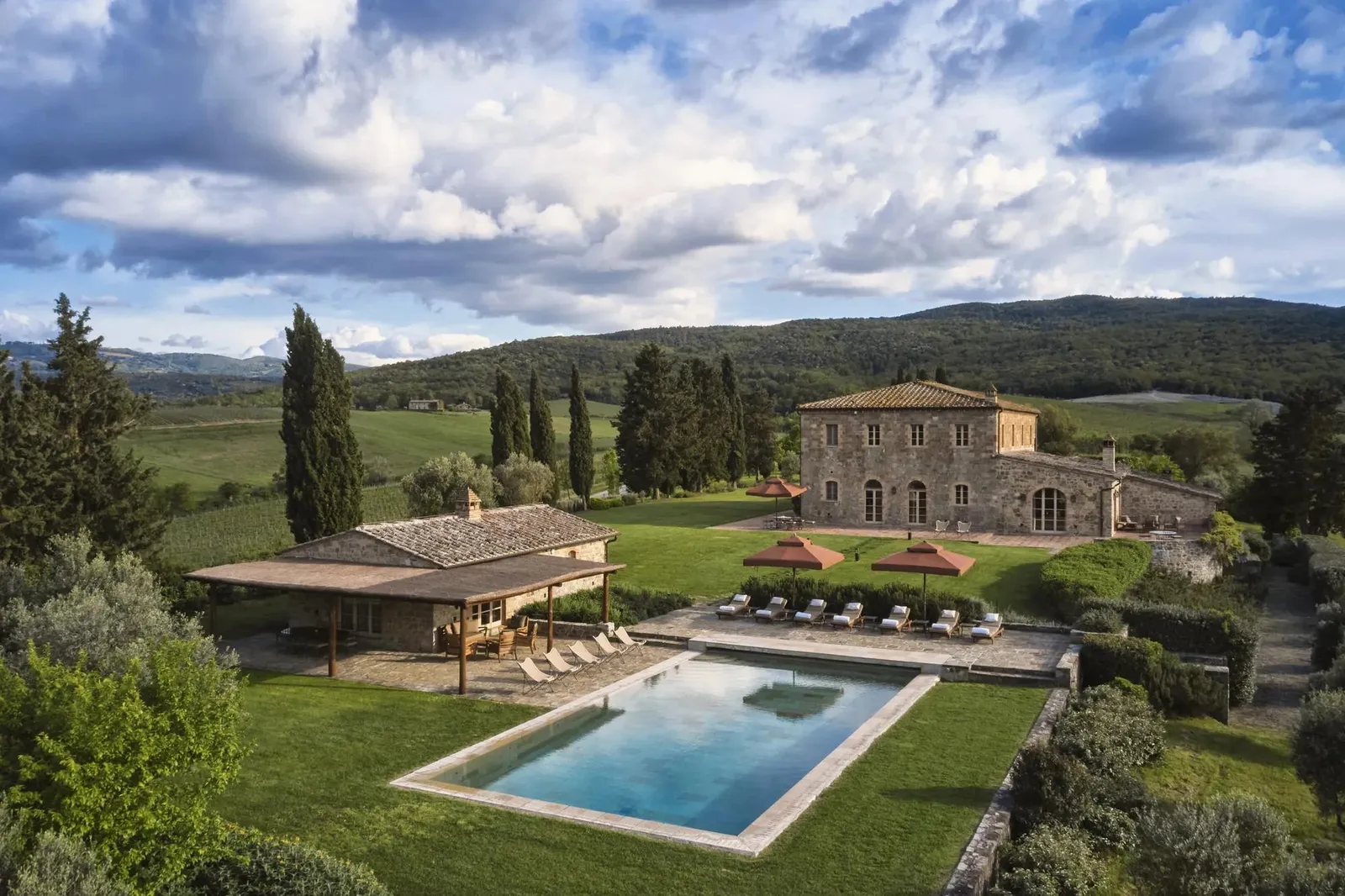 Villa Sant’Anna from above: the stone house, the pool house and the pool on the lawn.