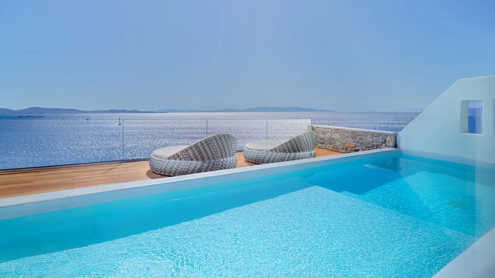 The private pool of the 2-bedroom Golden Villa, 2 wicker chairs at its edge and the open bay ahead.