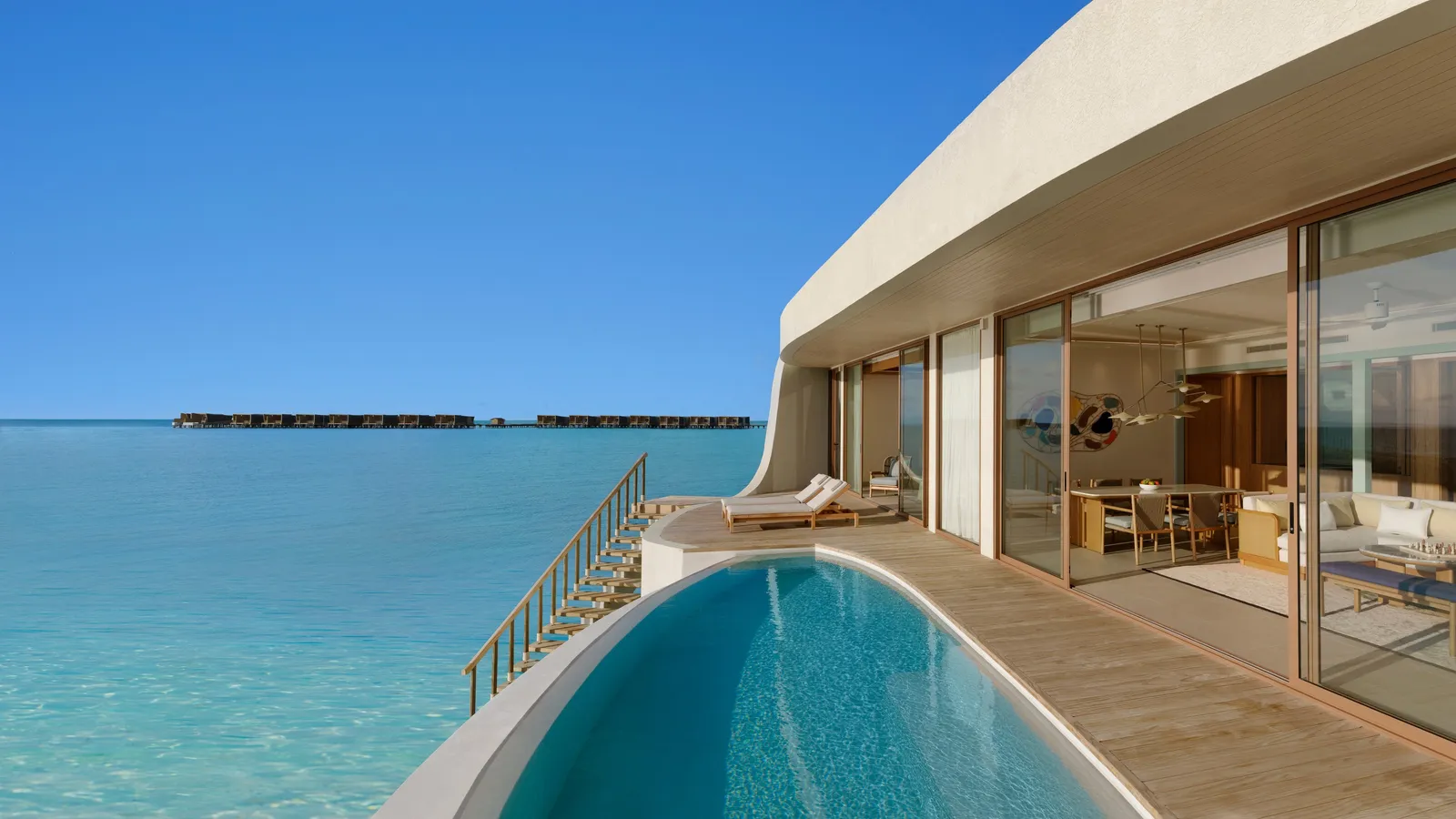 The long pool of the Three-Bedroom Sunset Overwater Pool Residence, its glass front and the sea