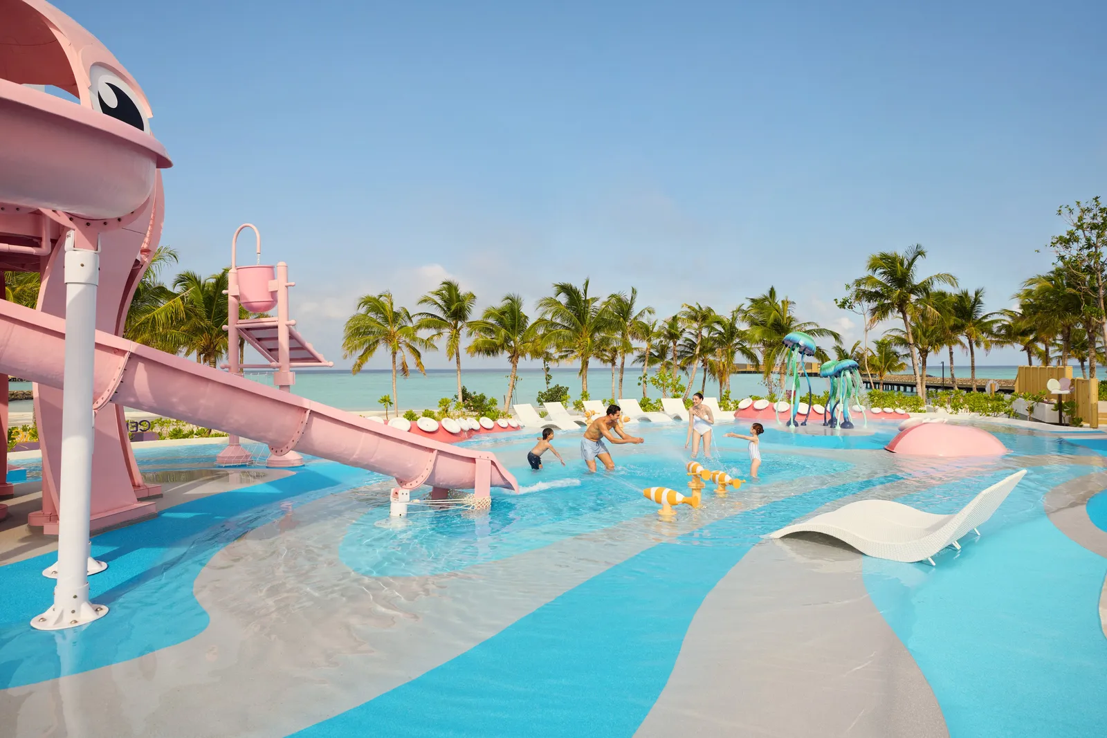The pink octopus and its slides in the children’s pool, among the palms