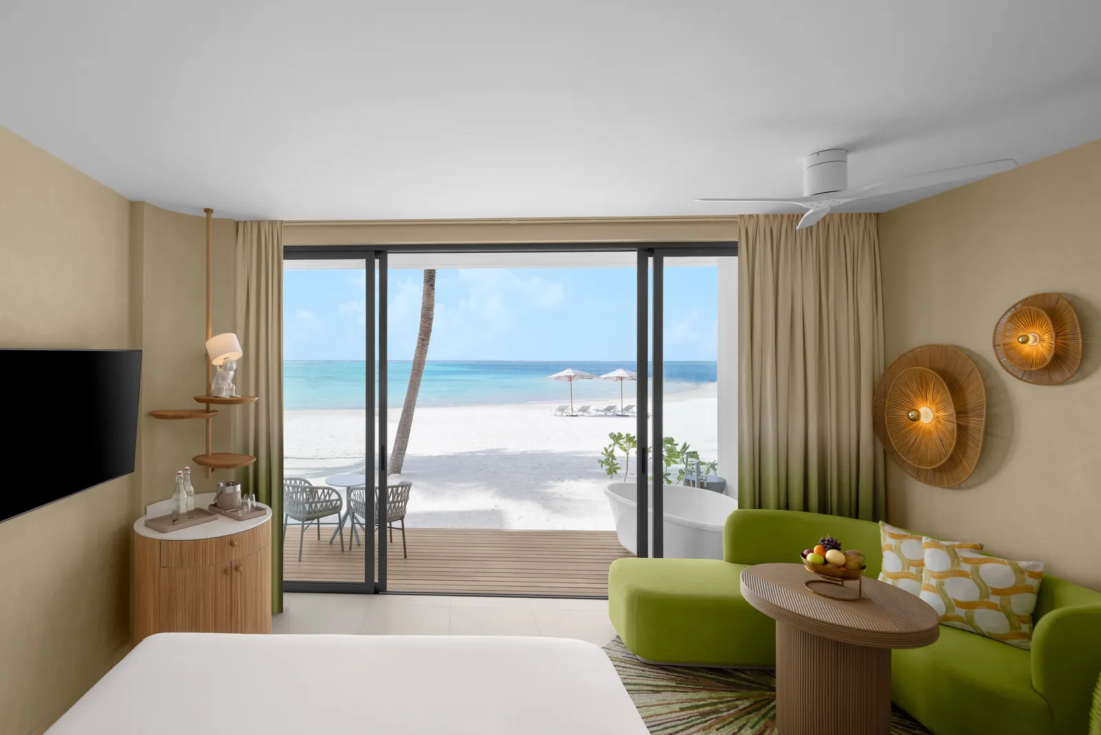 A Beachfront Room, its glass doors open to the terrace and the beach