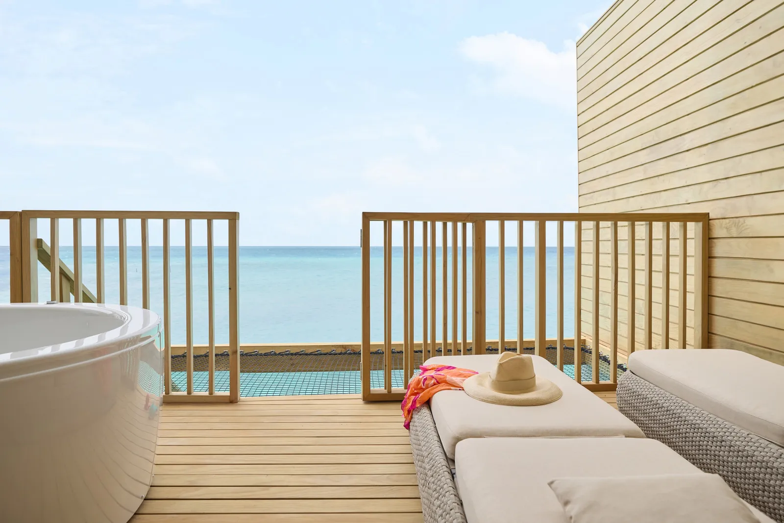 The deck of a Mirage Overwater Villa: the Jacuzzi, the daybed and the open sea