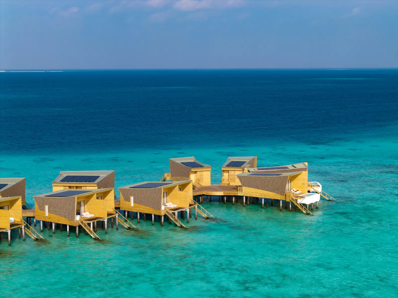 The row of water villas from above, over the turquoise lagoon
