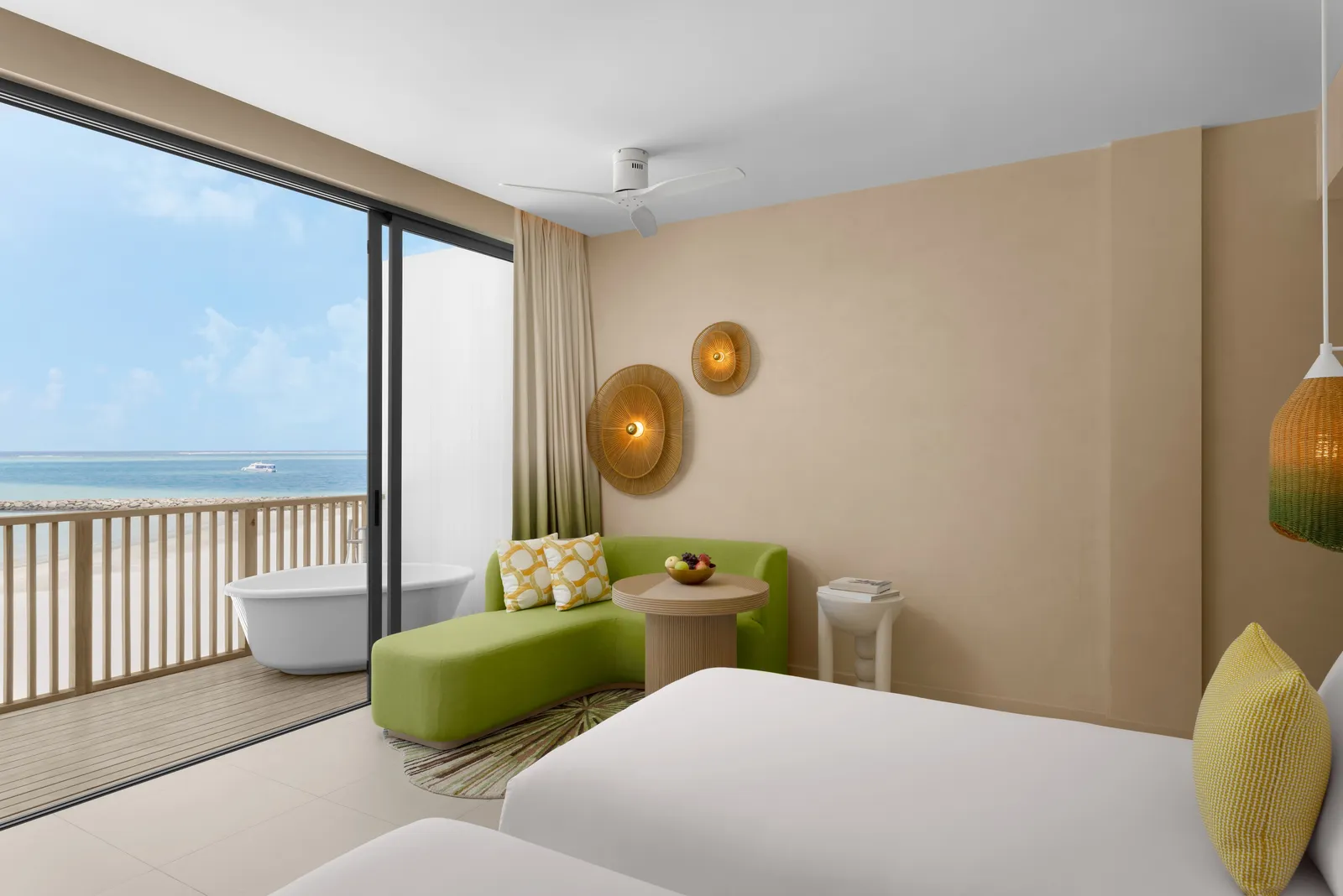 A Panoramic Lagoon Room: the bed, the green sofa and the bath on the balcony facing the lagoon