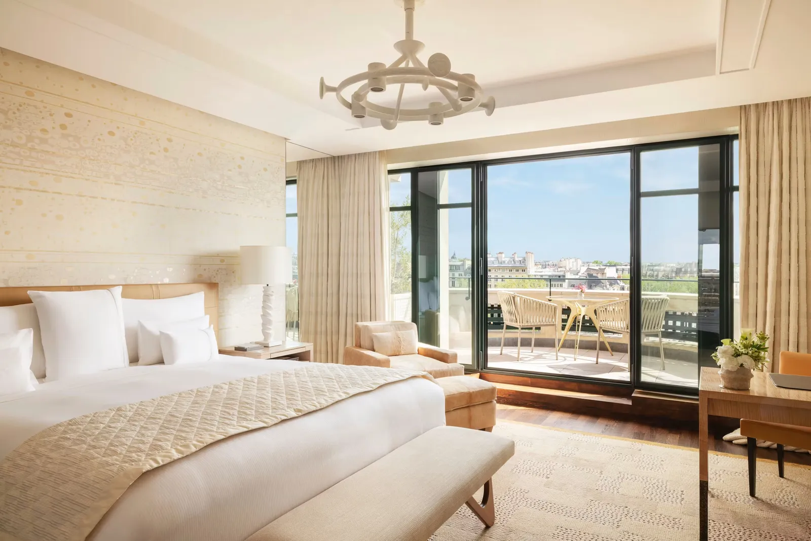 A bedroom with a bed and windows opening onto a balcony