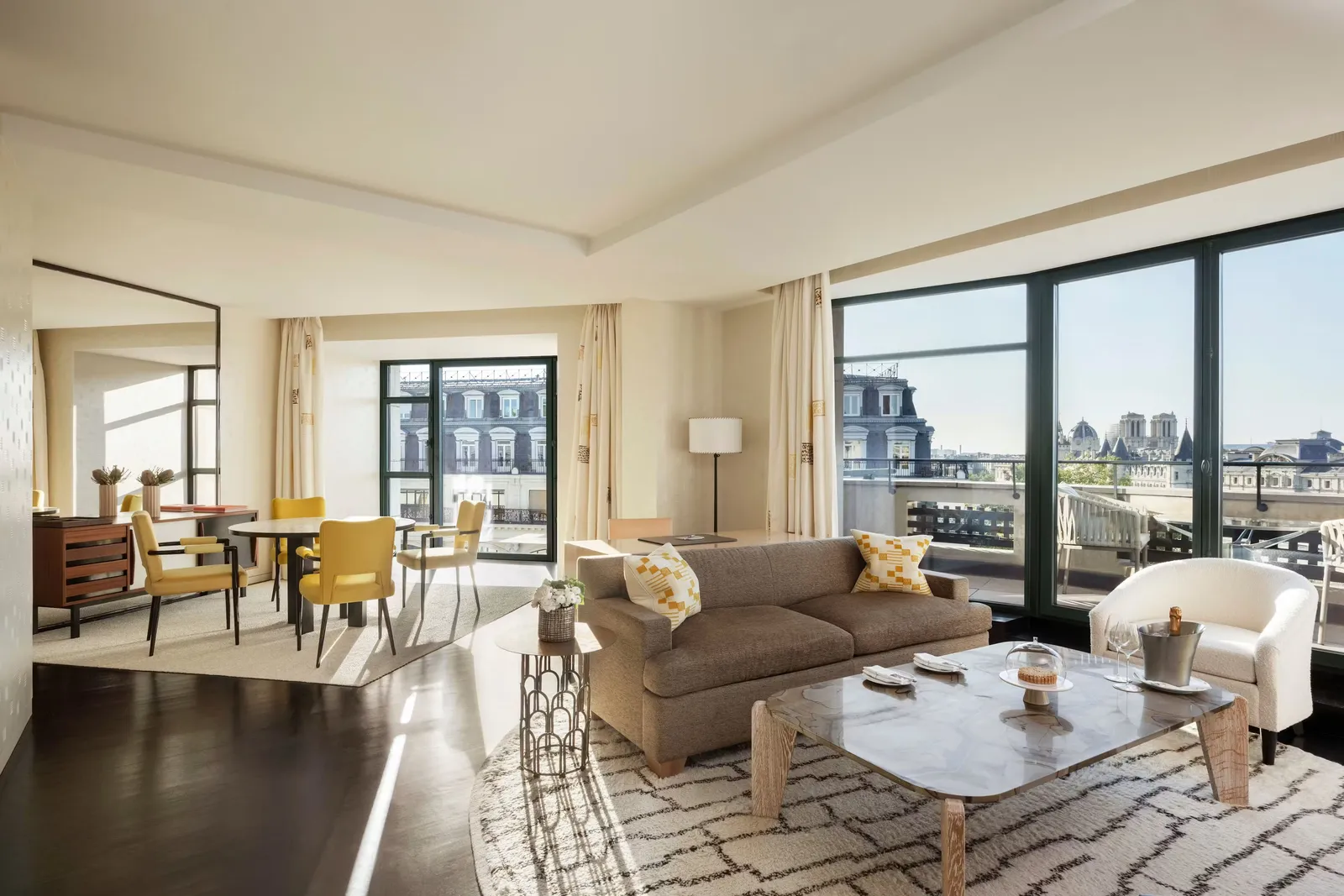 A sitting room with sofas and large windows