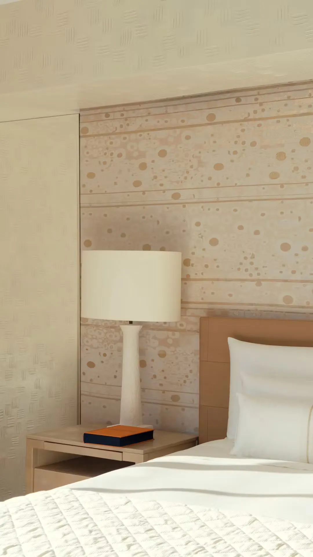 A detail of the bedroom bed, lamp and wall