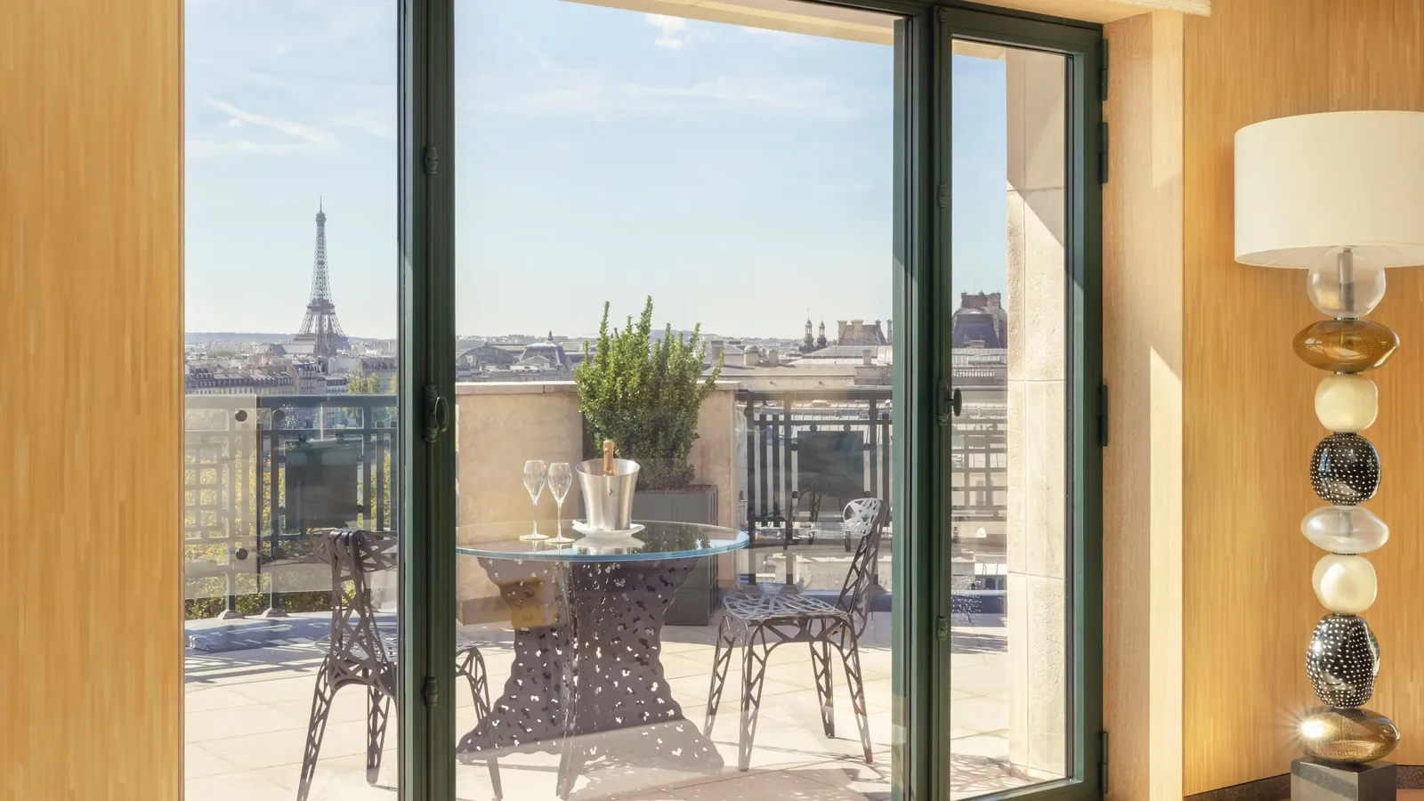 Windows opening onto a terrace with a table and chairs