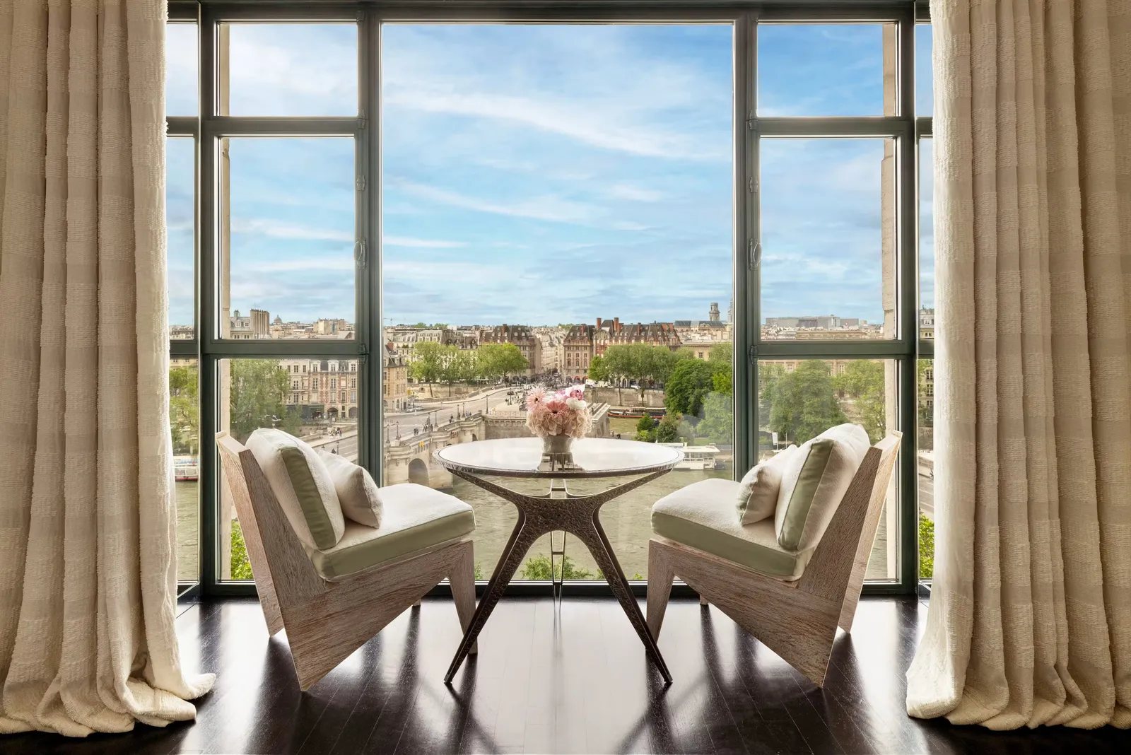 A winter garden with 2 armchairs and windows overlooking the Seine