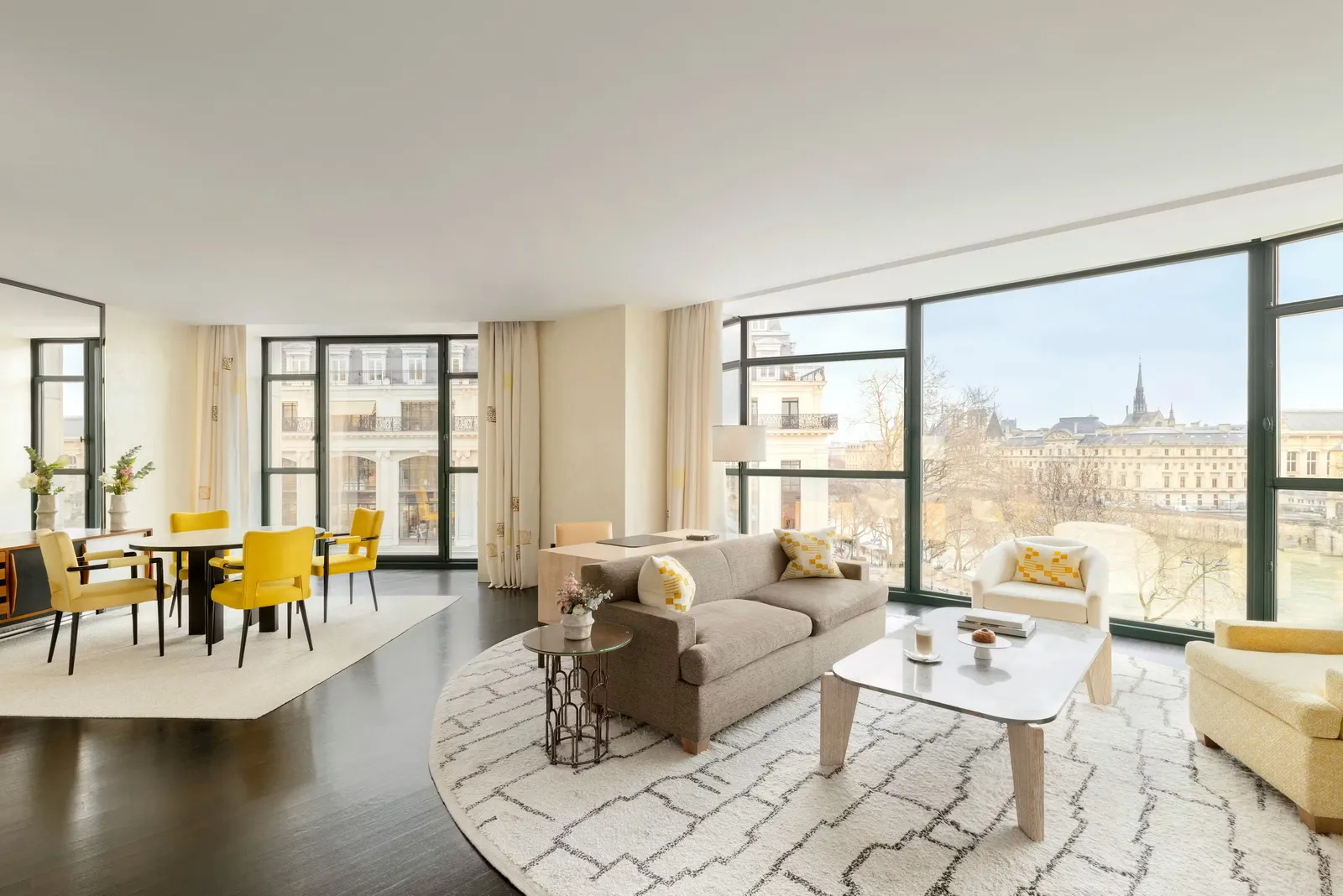 A sitting room with sofas, a round table and windows