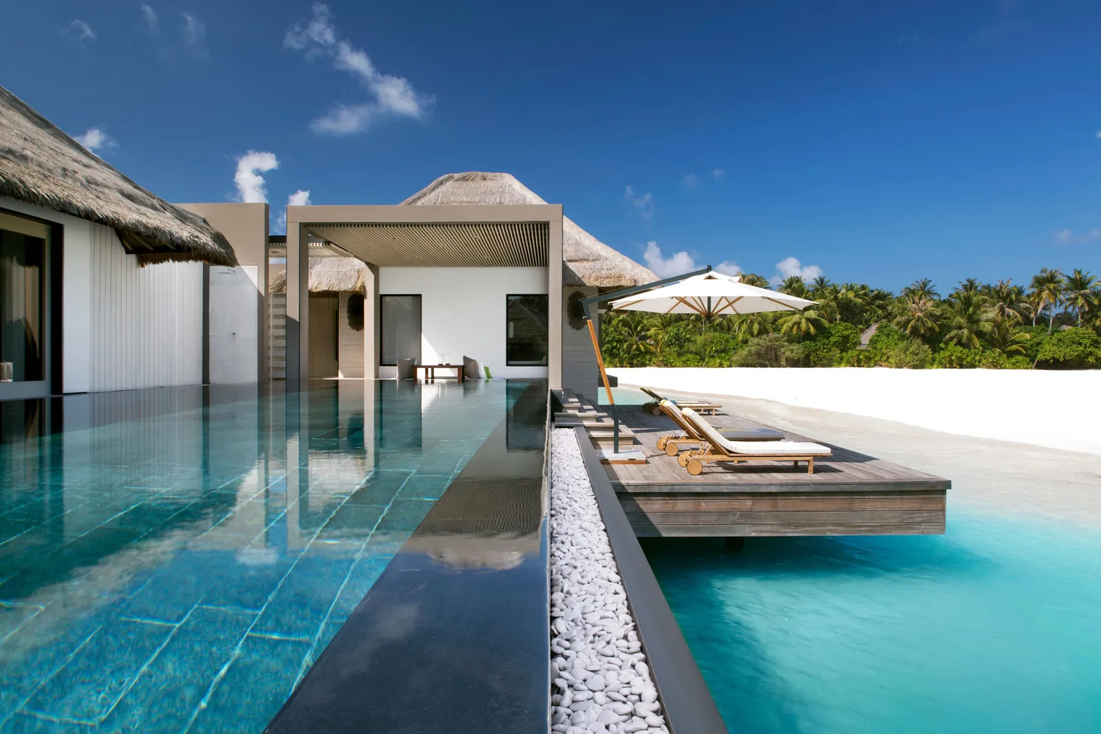 The infinity pool of a Lagoon Garden Villa, its deck and the lagoon behind