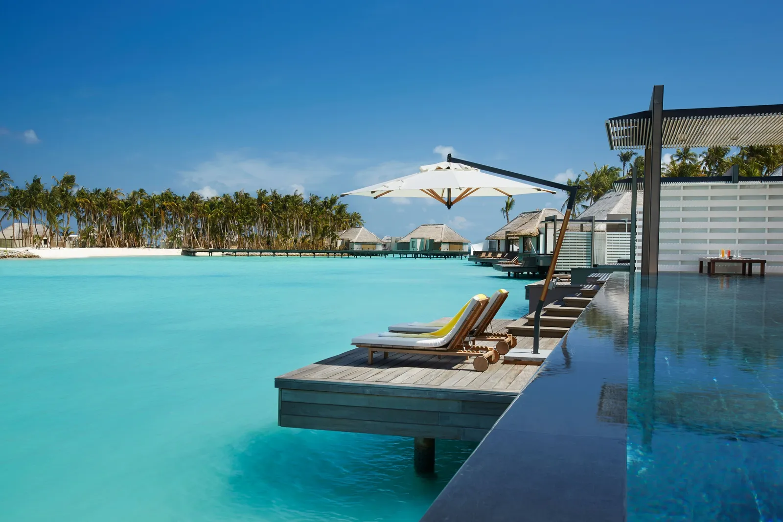 Lagoon Villa: loungers at the pool’s edge above the lagoon