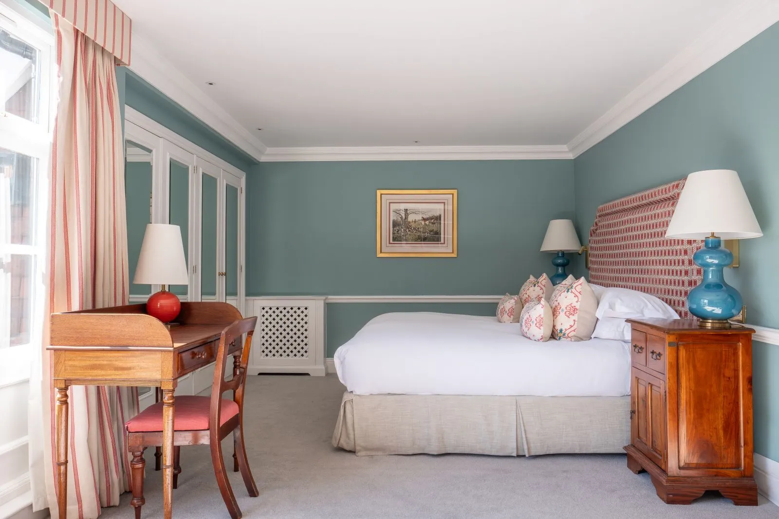A Classic Room with blue walls, a king bed and a writing desk
