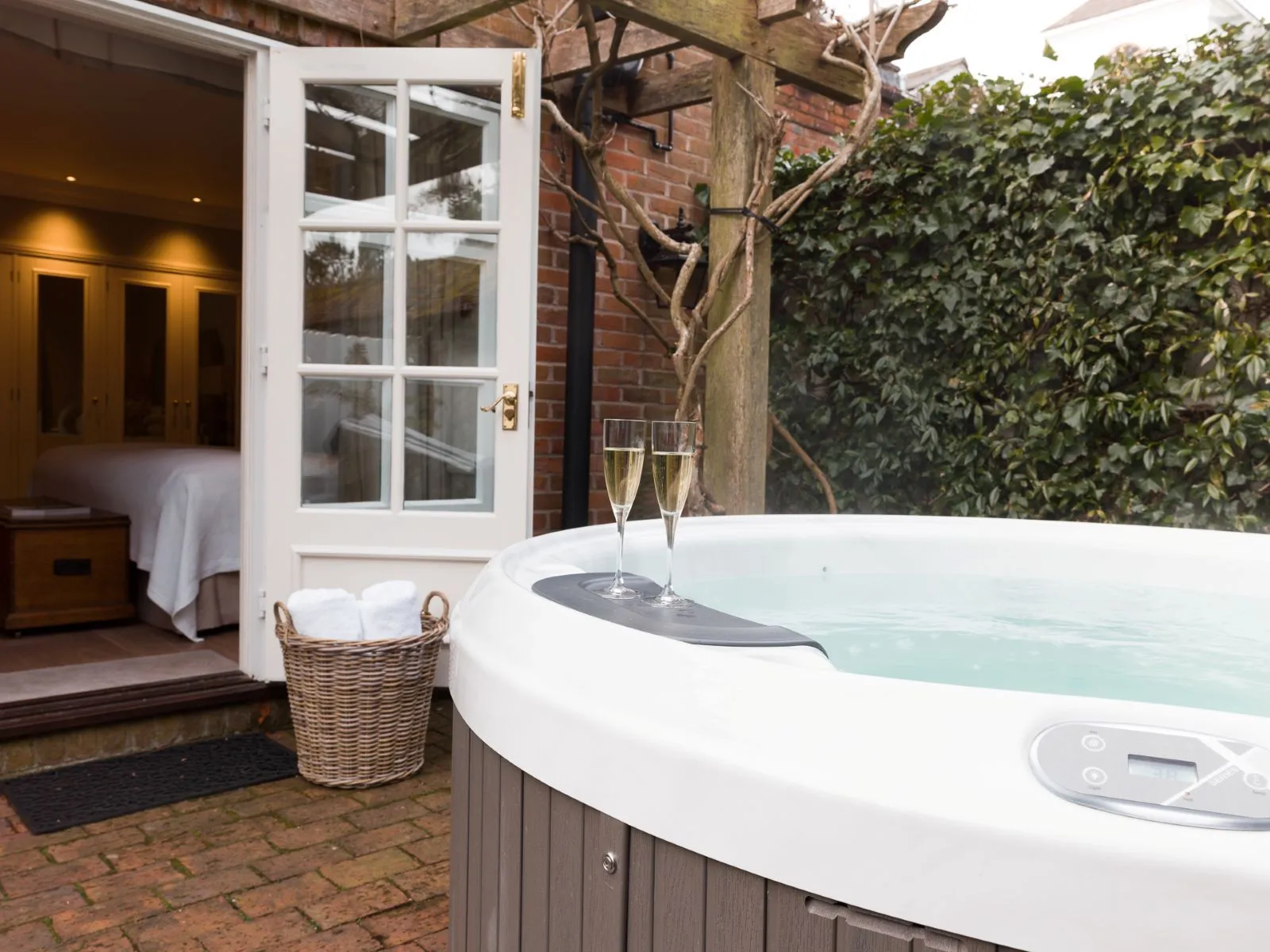 The hot tub in the brick courtyard, the door open into the suite