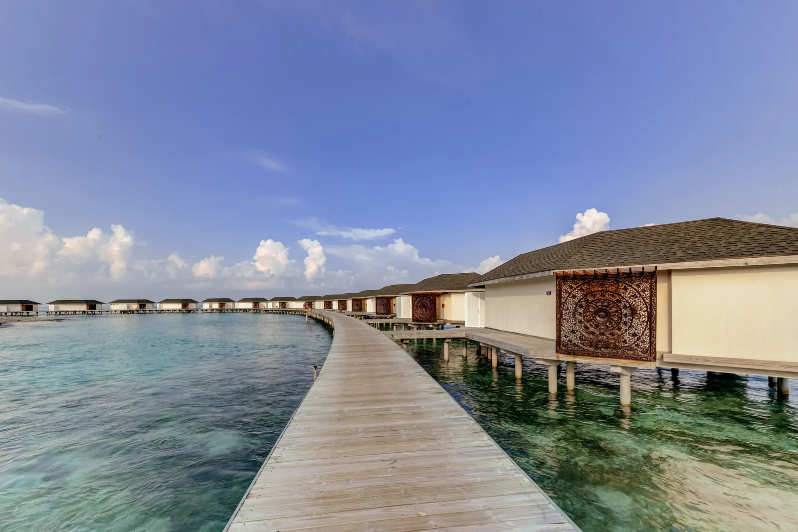 The curved jetty between the water bungalows and the lagoon