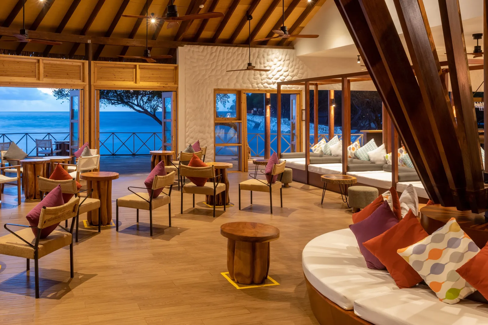 Raiyvilla’s lounge with armchairs, cushions and timber beams