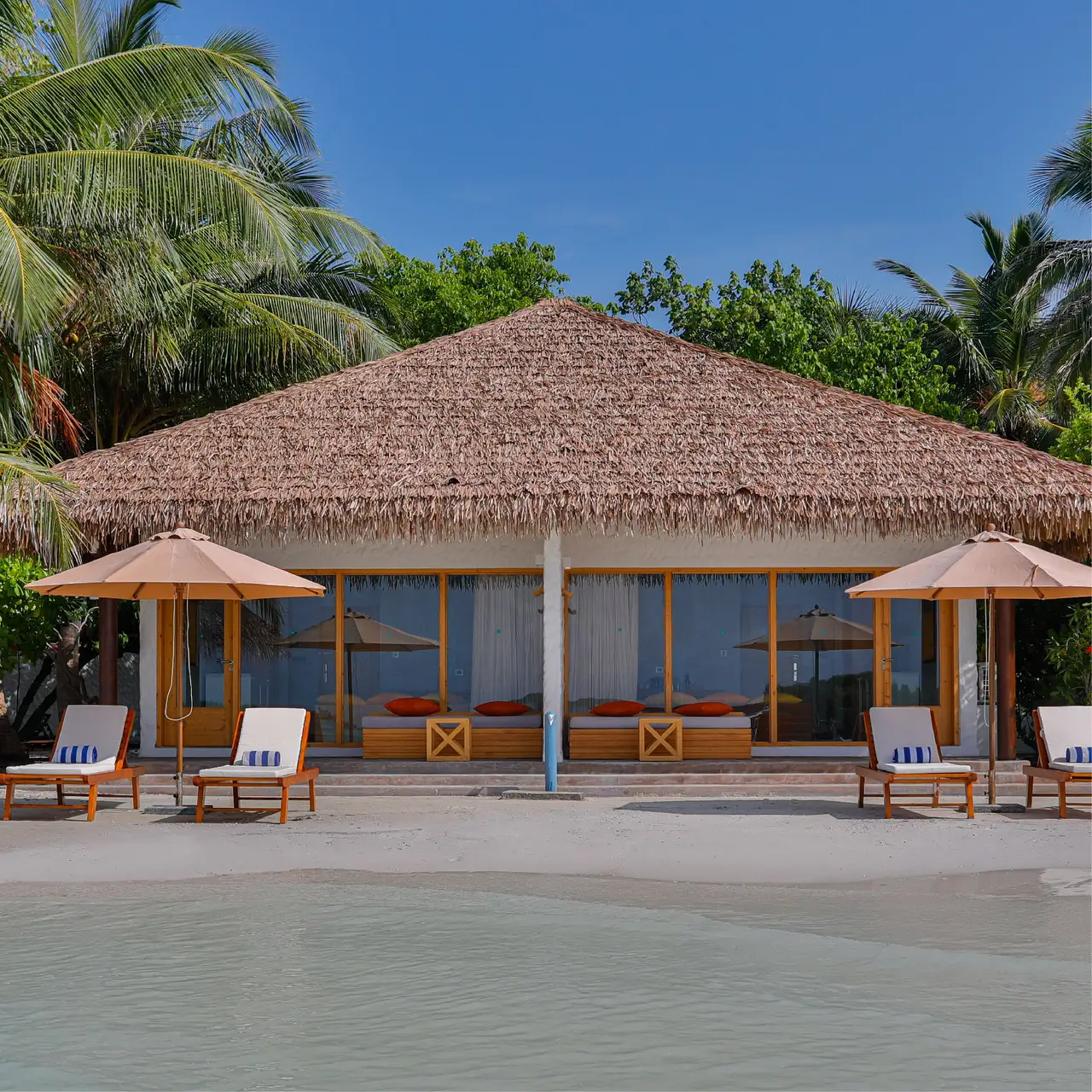A Beach Bungalow seen from the beach, its veranda beneath the thatched roof