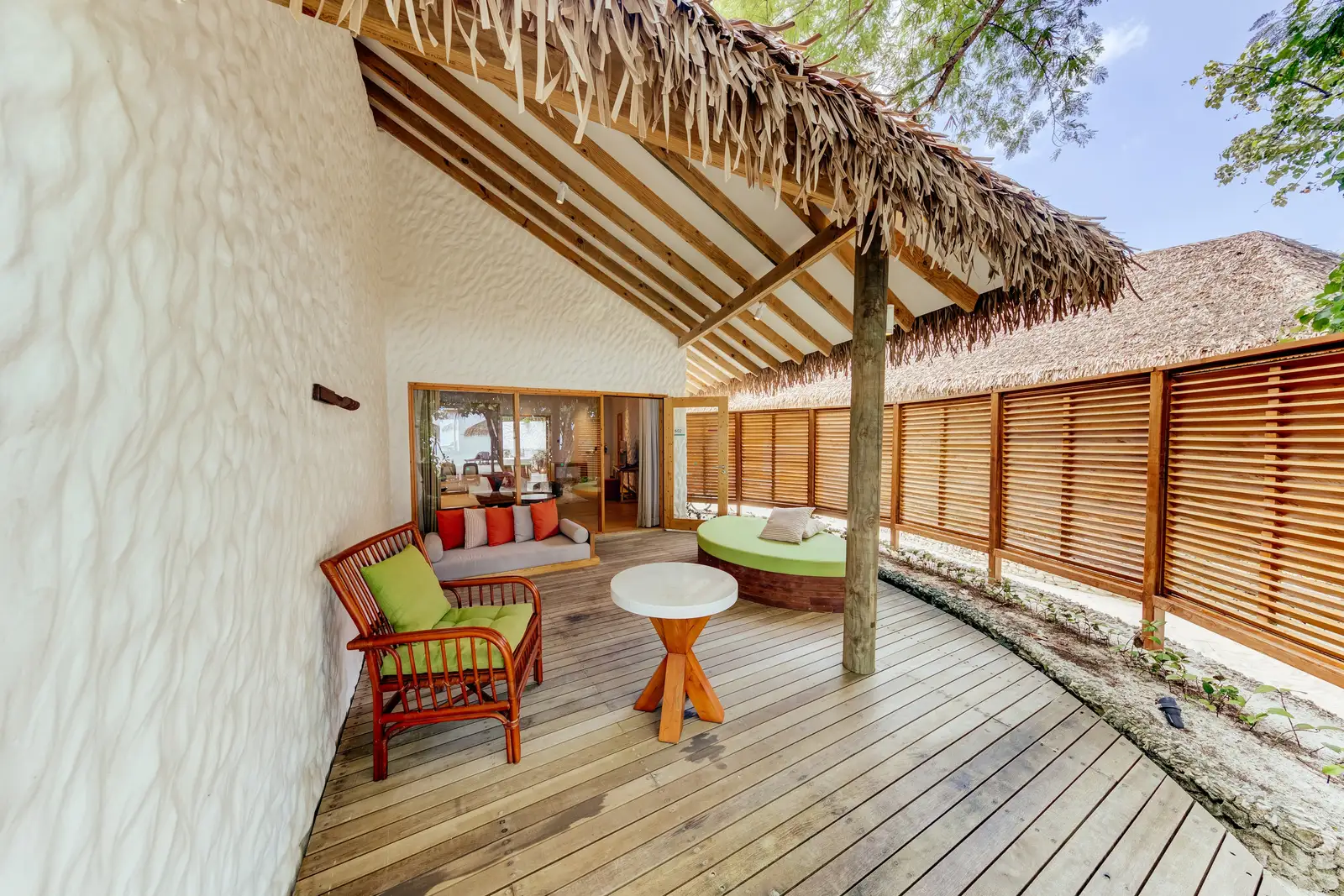 A Junior Beach Suite’s terrace with a table and chairs on the beach