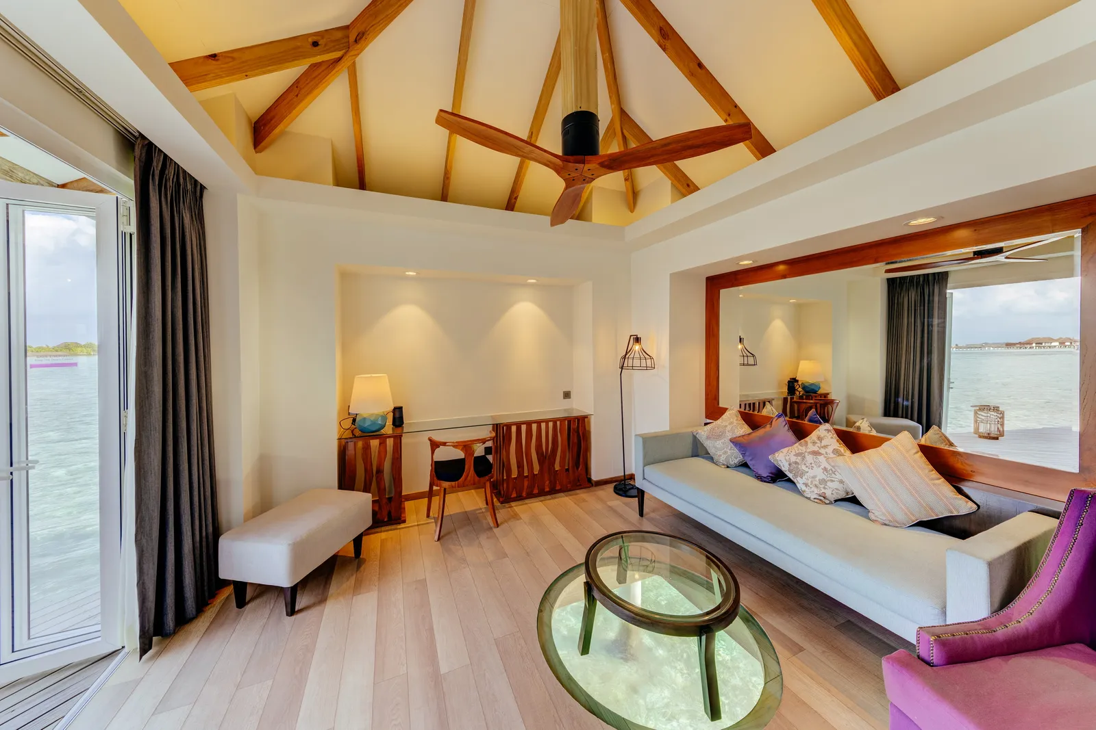 An Over Water Suite’s lounge with doors open onto the terrace