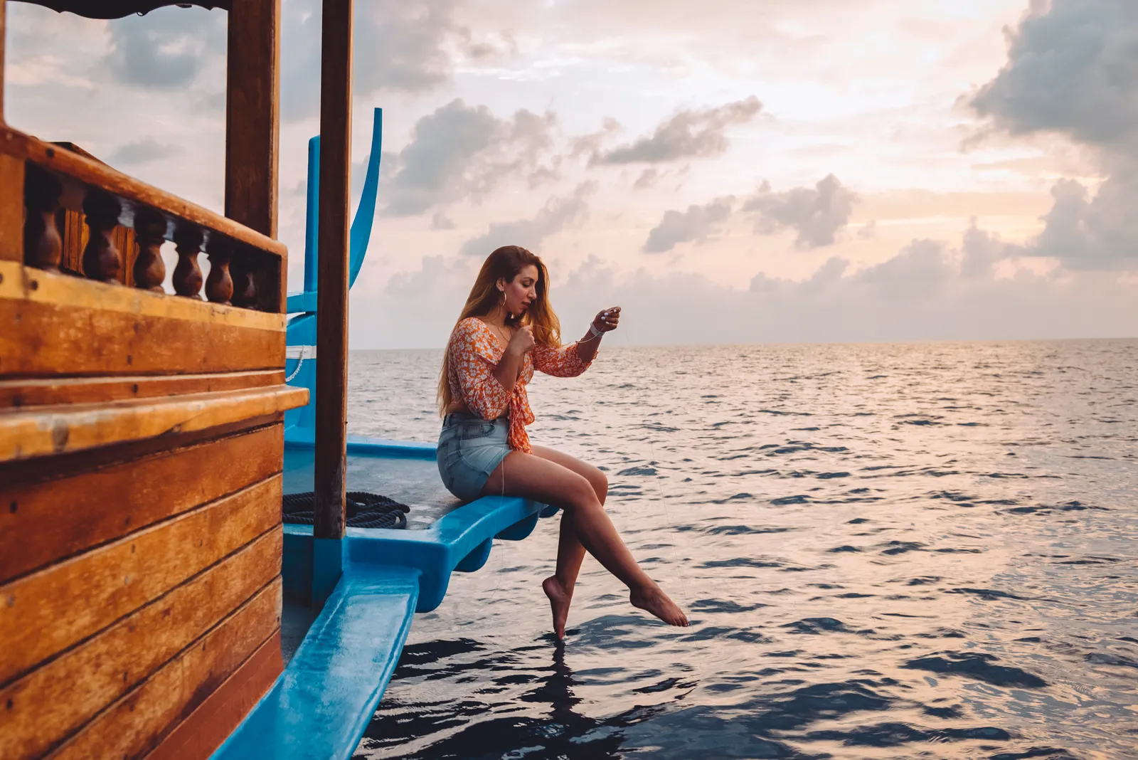 A guest fishing from the boat at sunset