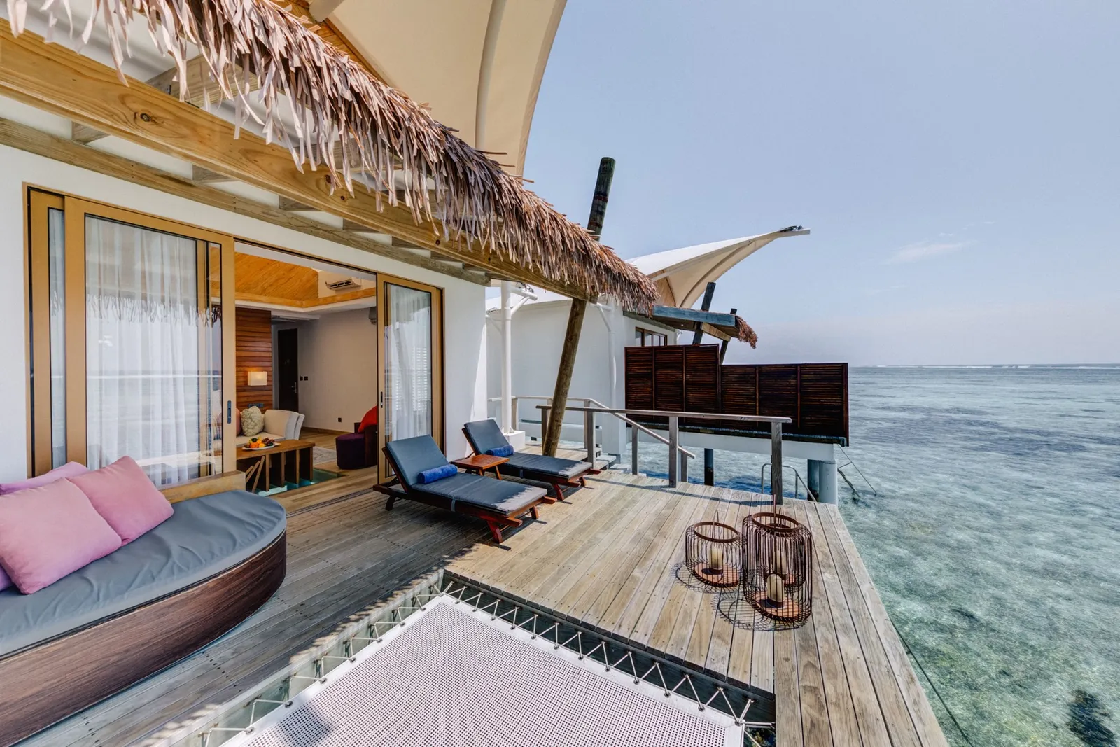 A Sunset Water Bungalow deck facing the open sea, with its net slung over the water and the loungers