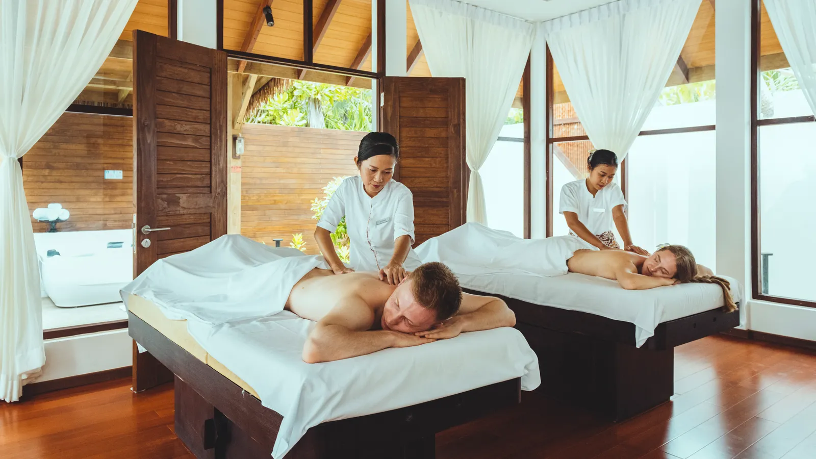 2 massages in a Mandara Spa room, white curtains open to the greenery