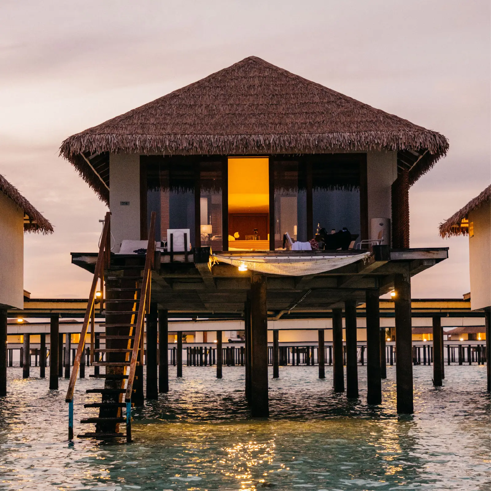 A Water Bungalow at sunset, with its deck and lagoon steps