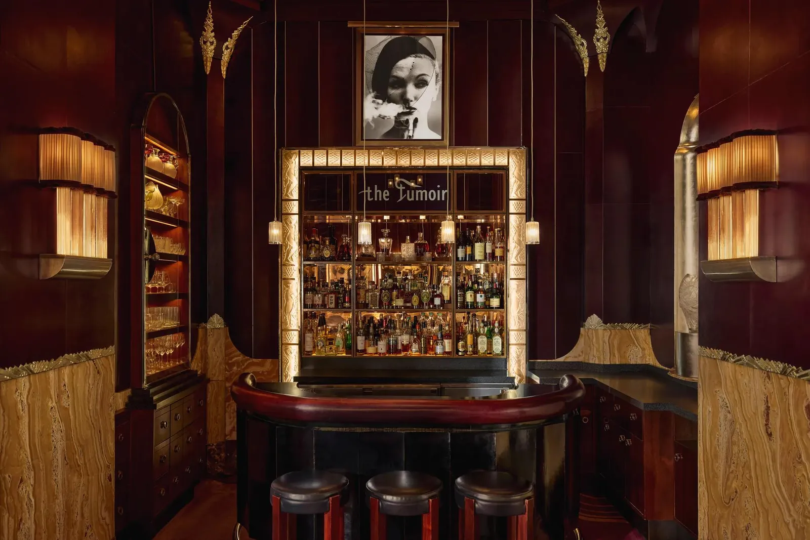 The Fumoir: red velvet banquettes, low lamps and bottles behind the bar