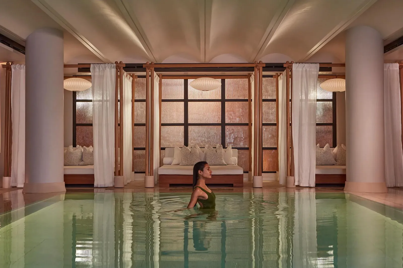 The spa pool under its pale vaulted ceiling, stone columns and cabanas beyond