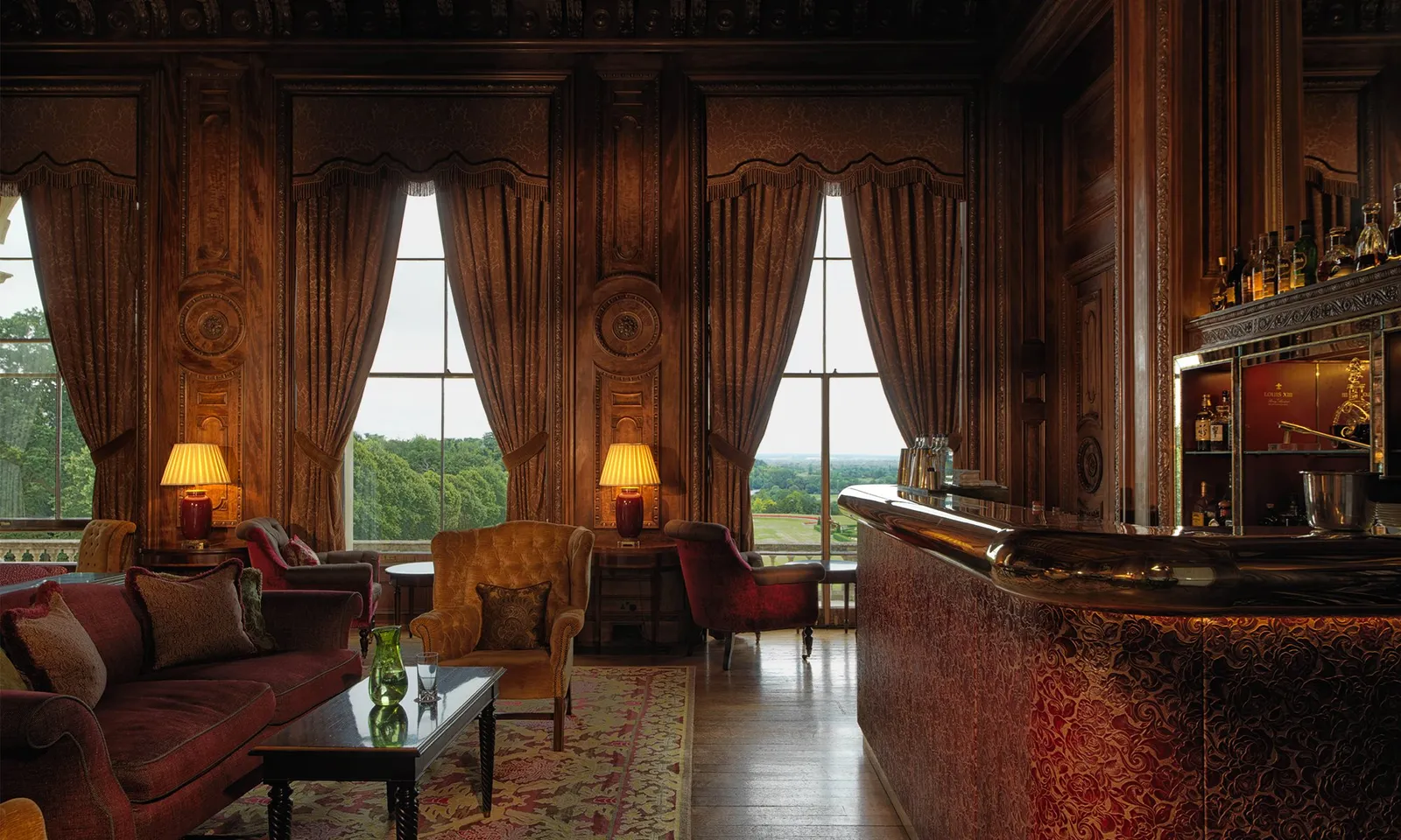 The Library Bar: dark panelling, red velvet armchairs and tall windows onto the garden