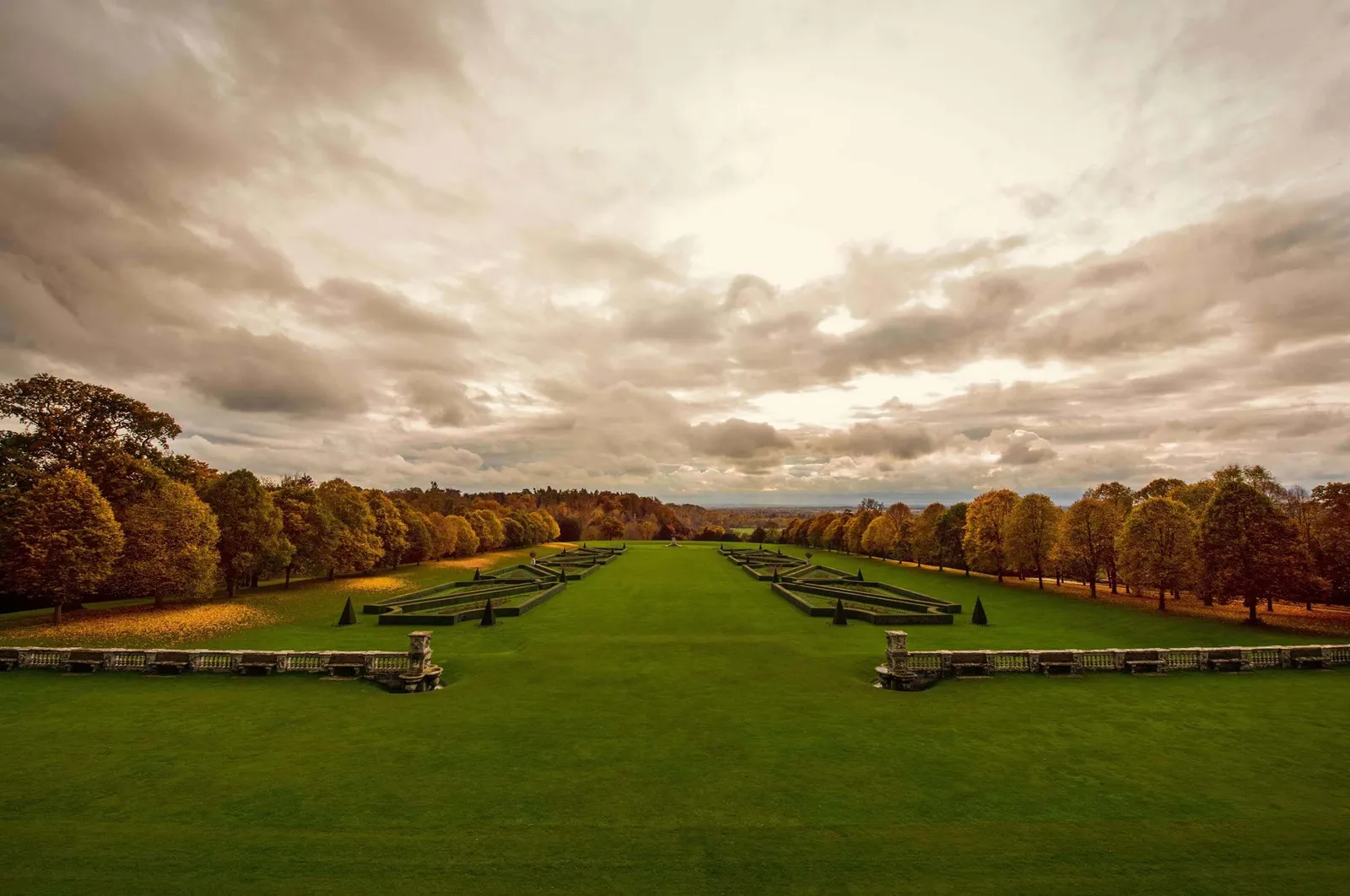 The Parterre in autumn seen from the terrace, its geometric hedges and red trees