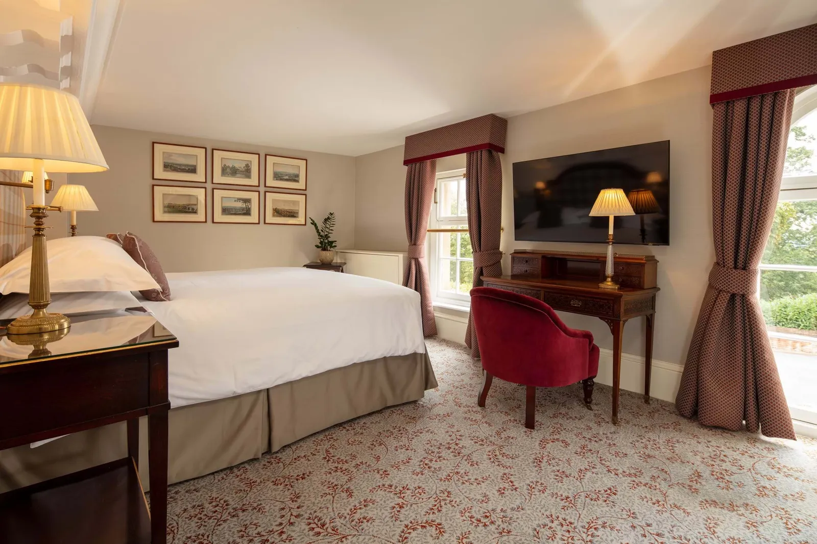The Bobbie Shaw room: a double bed, a desk with a television and a window with claret curtains