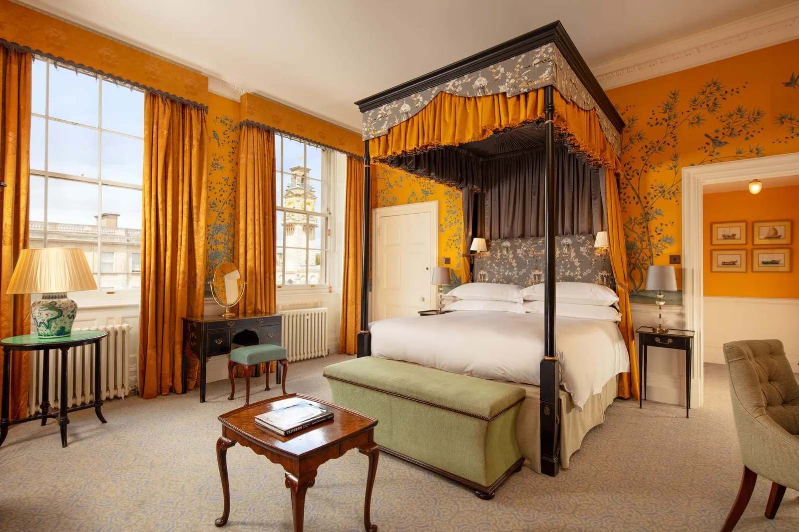 A Deluxe Double Room: a four-poster bed and yellow walls painted with birds and flowers
