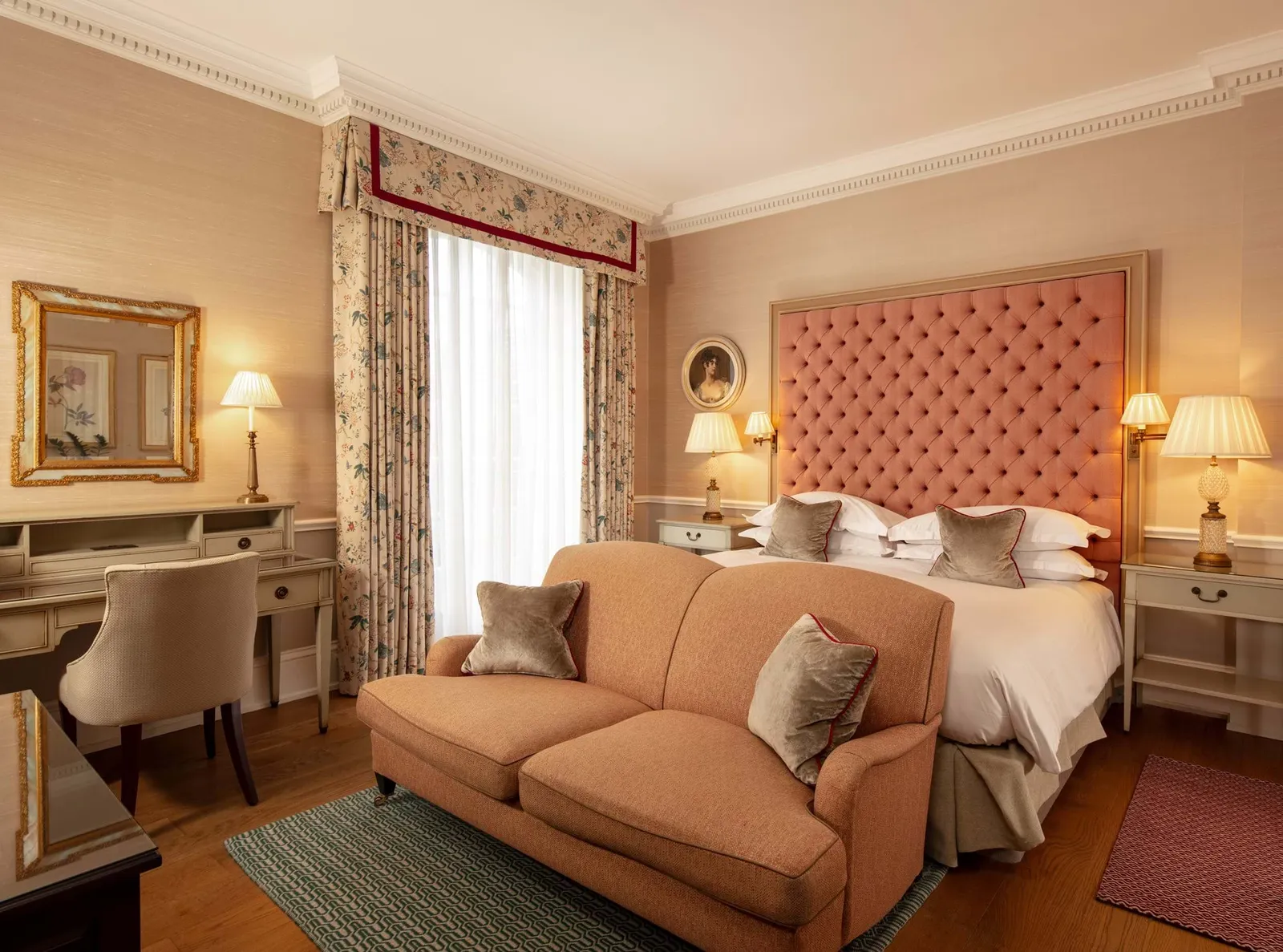 A Classic Room with a hot tub: a buttoned pink headboard, a salmon sofa and a desk