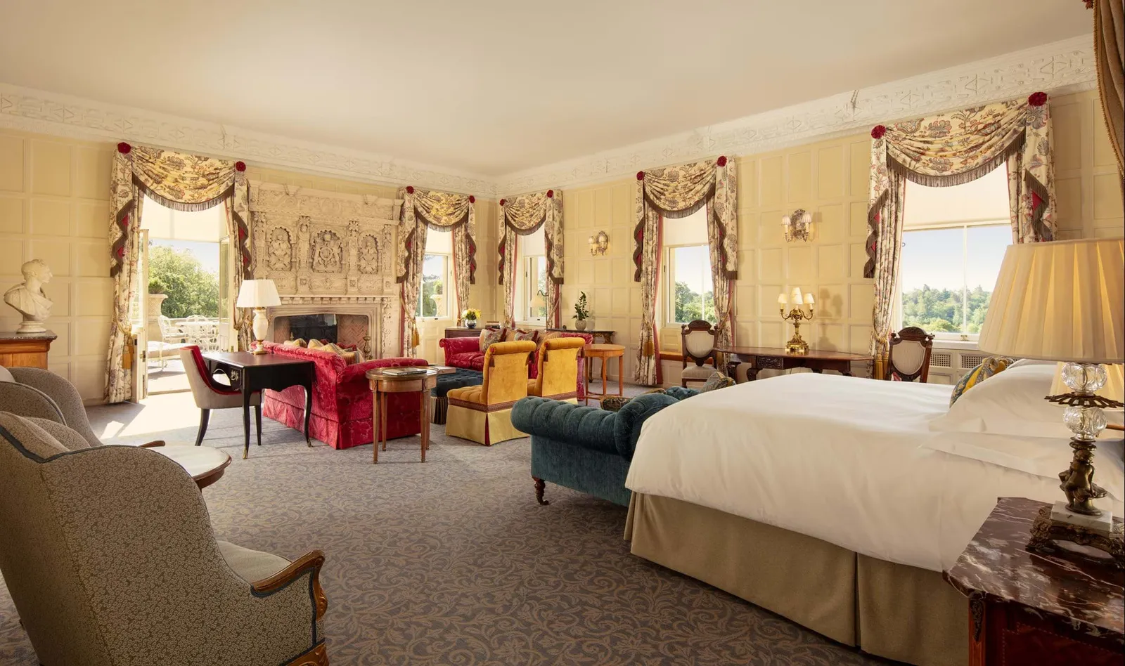 The Lady Astor Suite: a carved fireplace, yellow curtains and a row of windows onto the garden