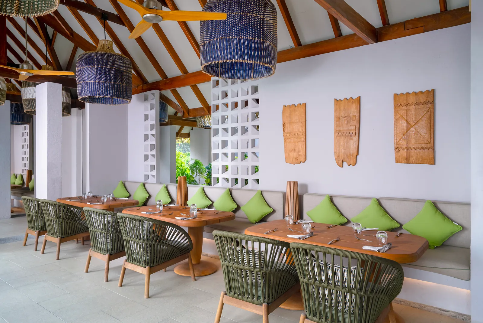 The Kandu’s dining room, with green rope chairs, lime cushions and rattan lamps.