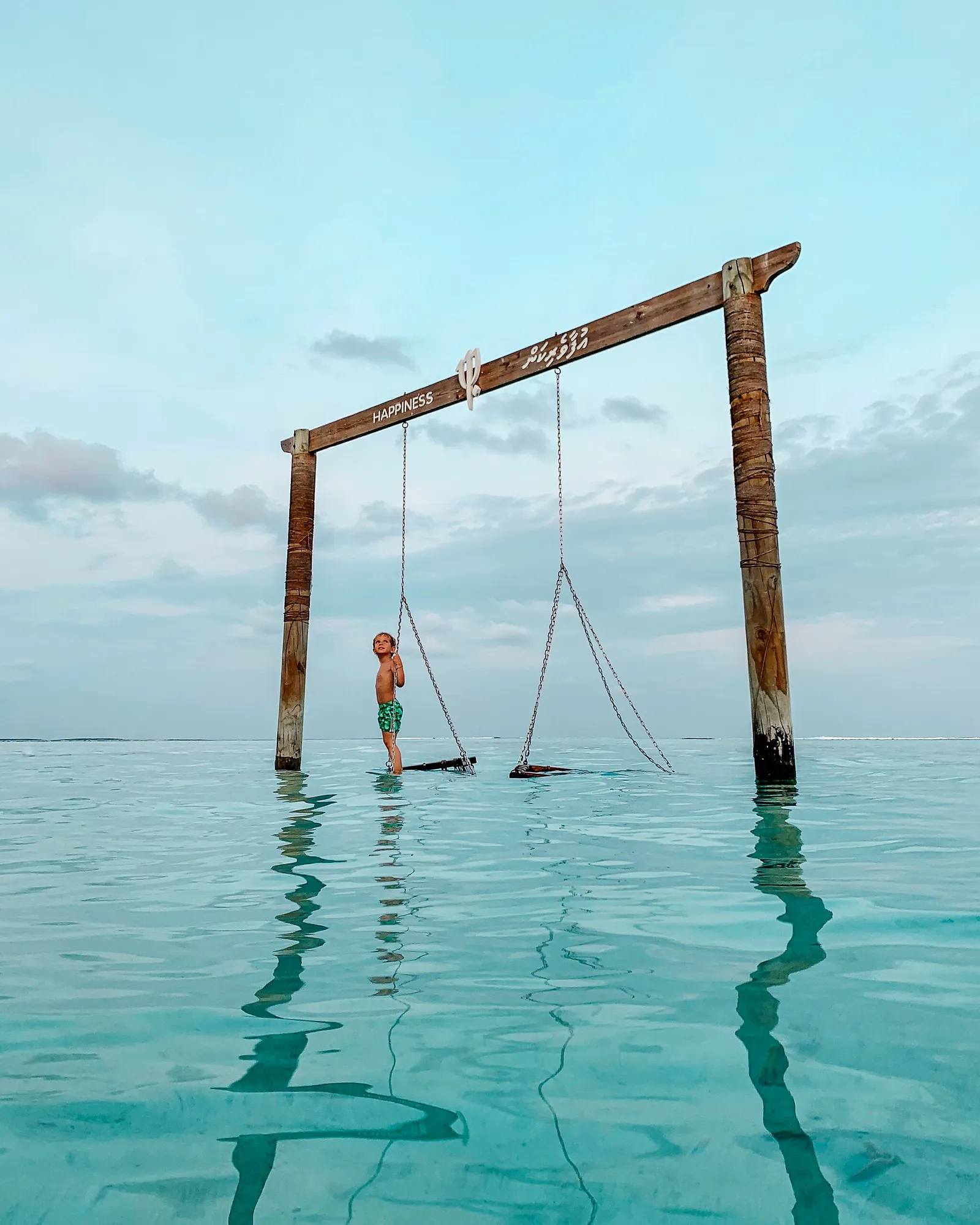 A child on the swing set in the lagoon’s shallow water.