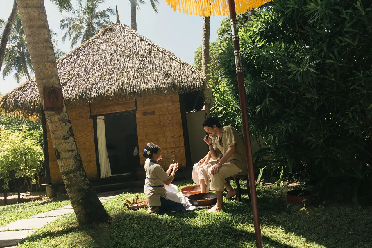 A foot treatment outside a thatched spa cottage, in the island’s garden.