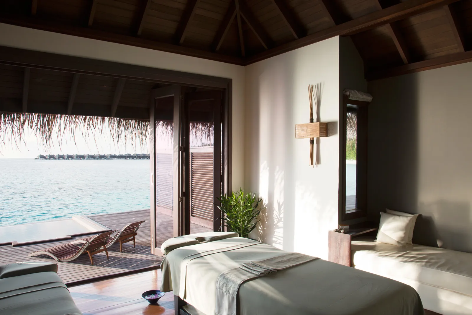 A Coco Spa treatment room: 2 massage beds and the door open to the deck and the lagoon.