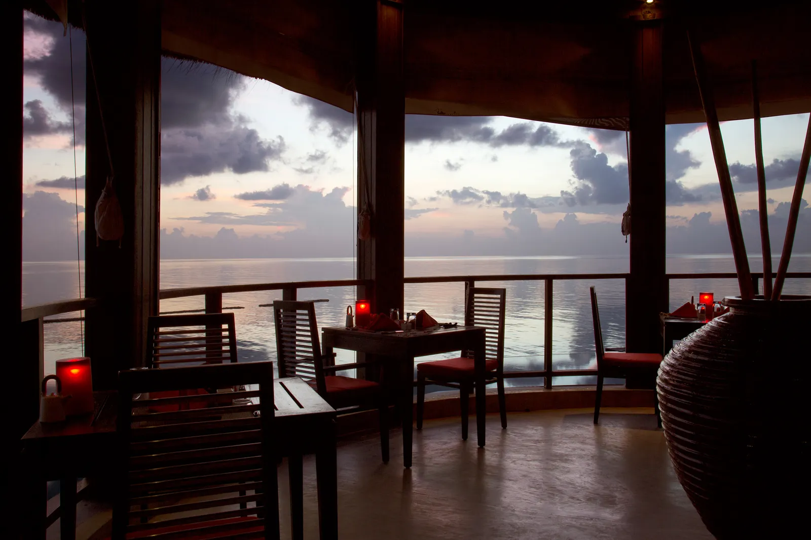 Tsuki, the Japanese restaurant, at dusk: tables laid by the open windows over the lagoon.