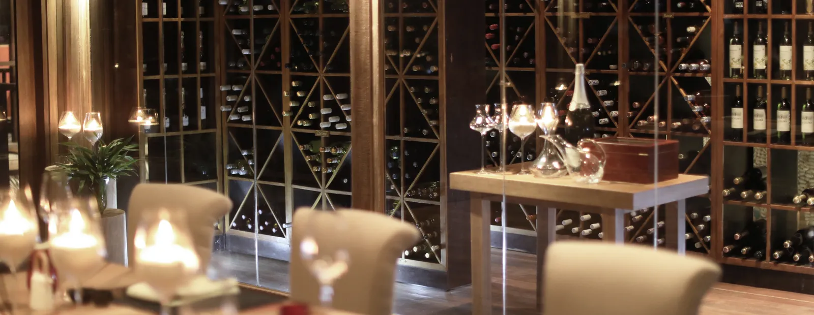 The Wine Loft in the evening: bottles in the timber racks, candles lit and tables laid.