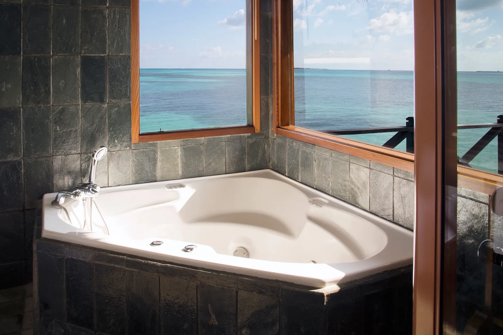 A Lagoon Villa’s corner jacuzzi bath, under windows that open onto the lagoon.