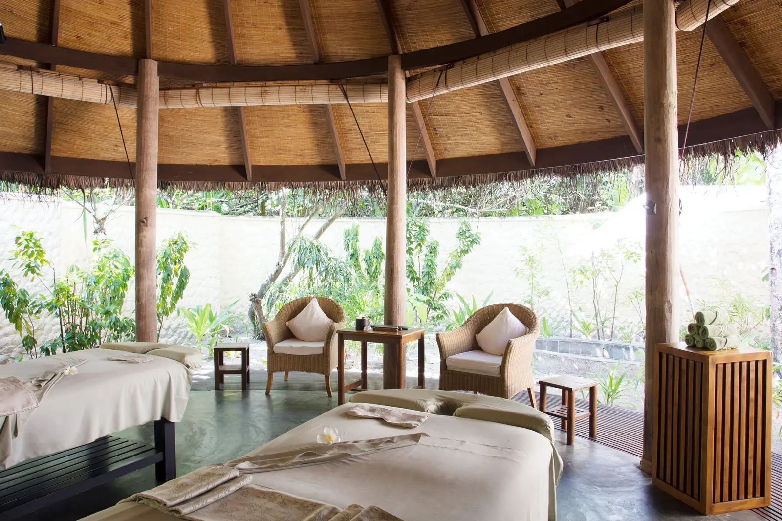 2 massage beds under the spa’s timber pavilion, with 2 armchairs, open to the garden.
