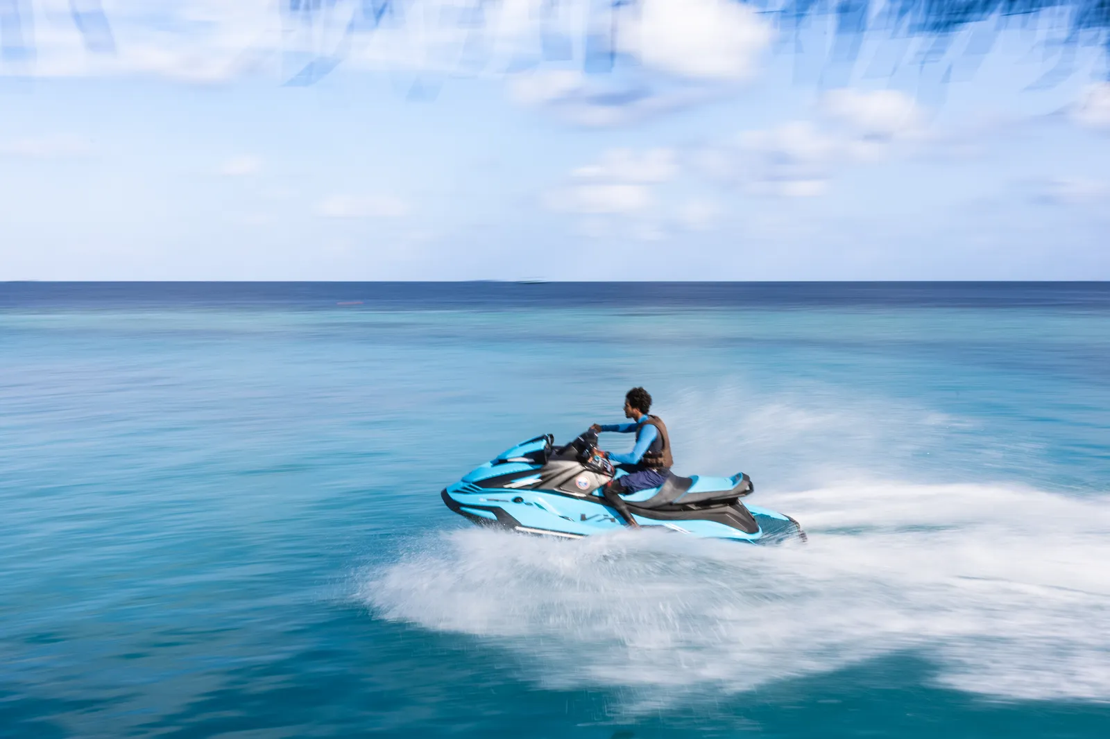 A jet ski throwing up spray across the turquoise lagoon.