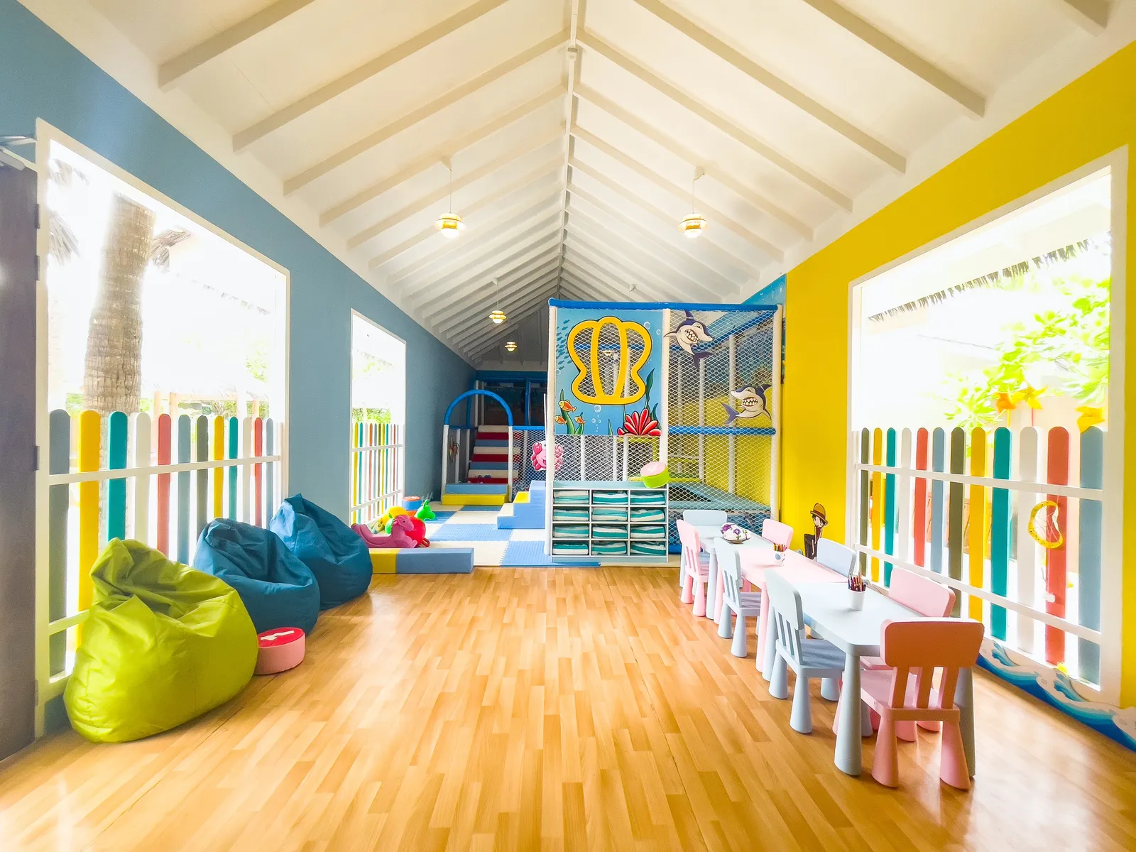 The Kids Village room: coloured beanbags, small tables and the play frame at the back