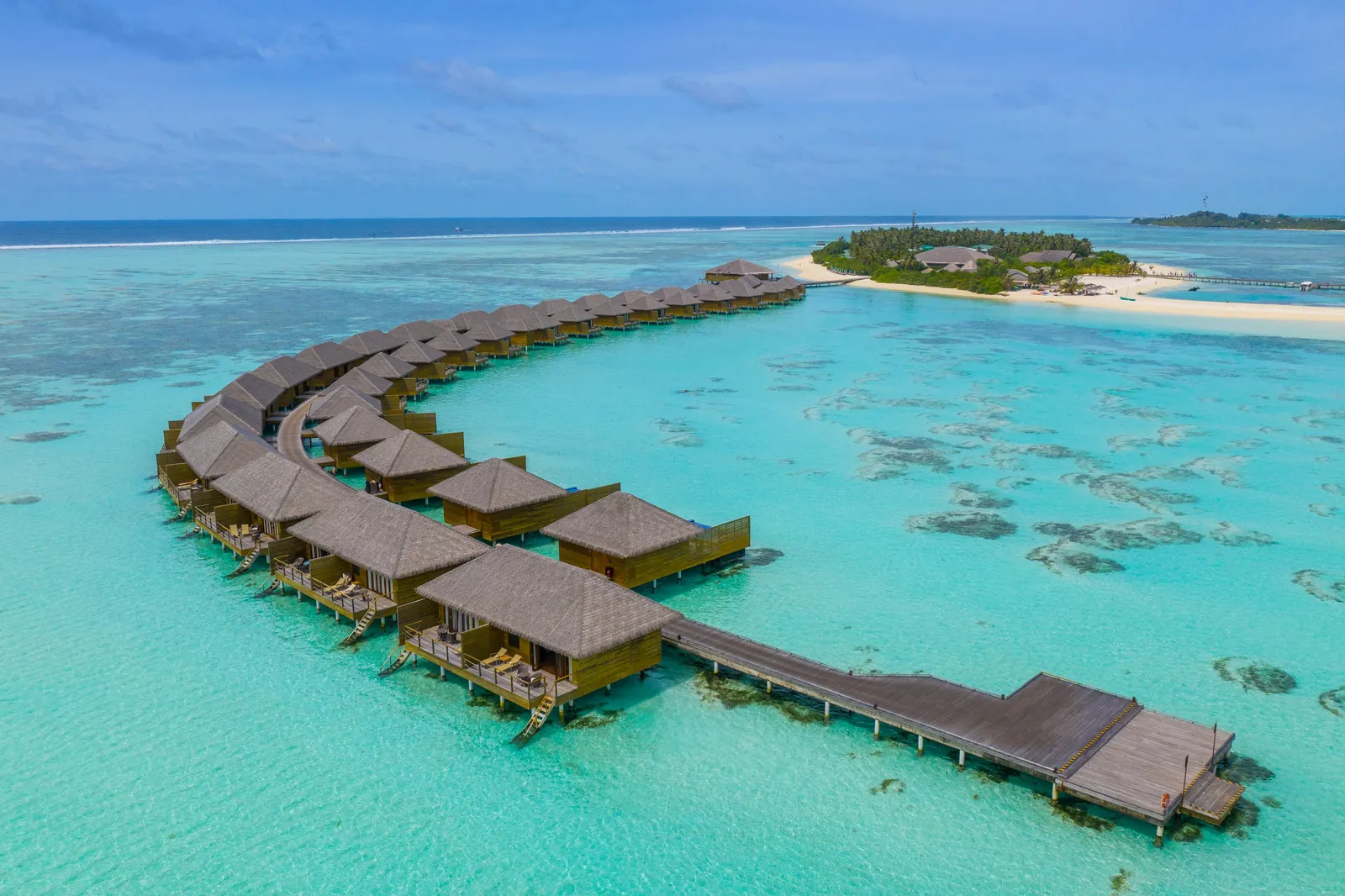 The lagoon villas in a row on the curving jetty, the island beyond