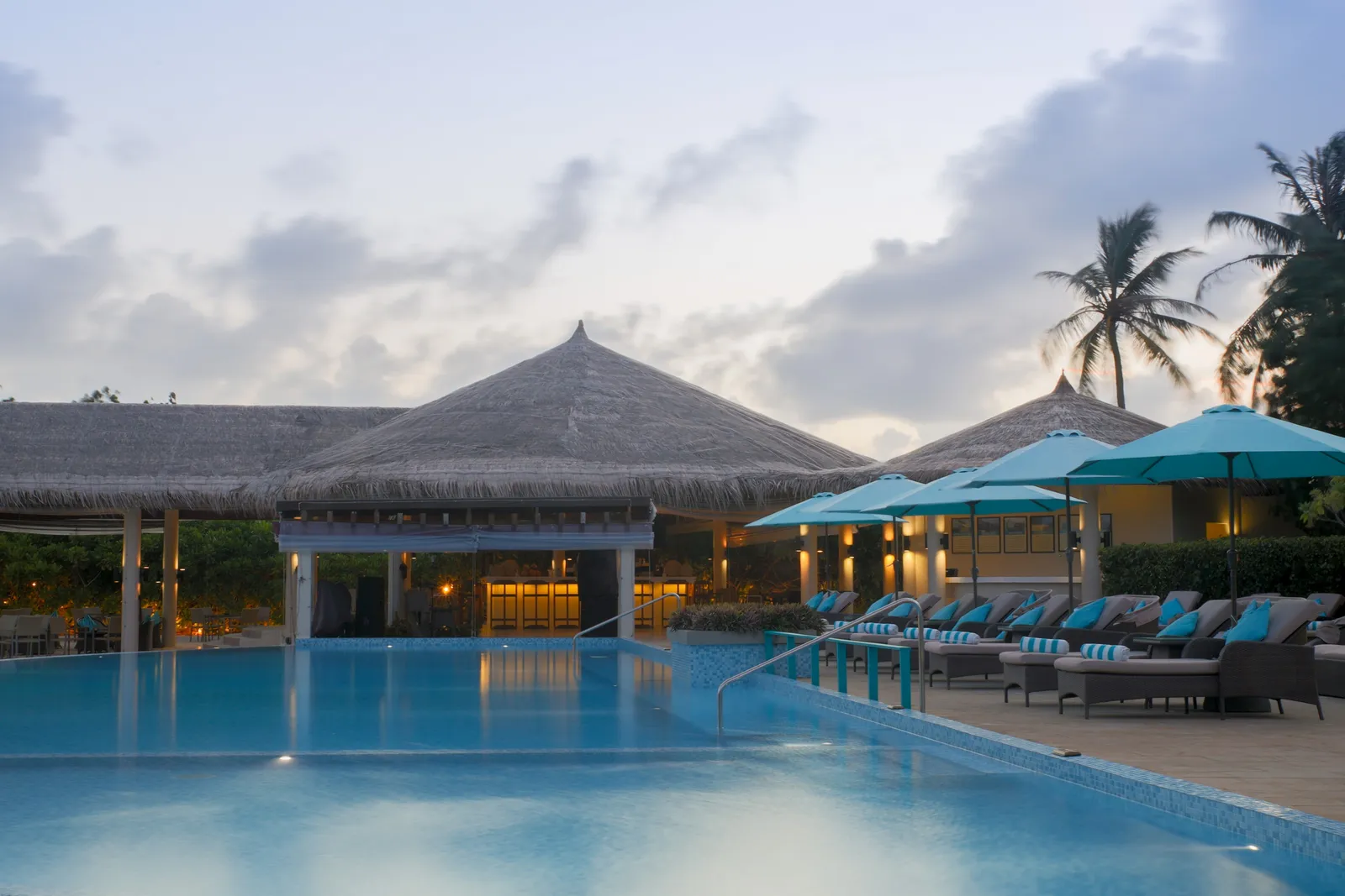 The main pool at dusk, the loungers and the Loabi Loabi Bar pavilion