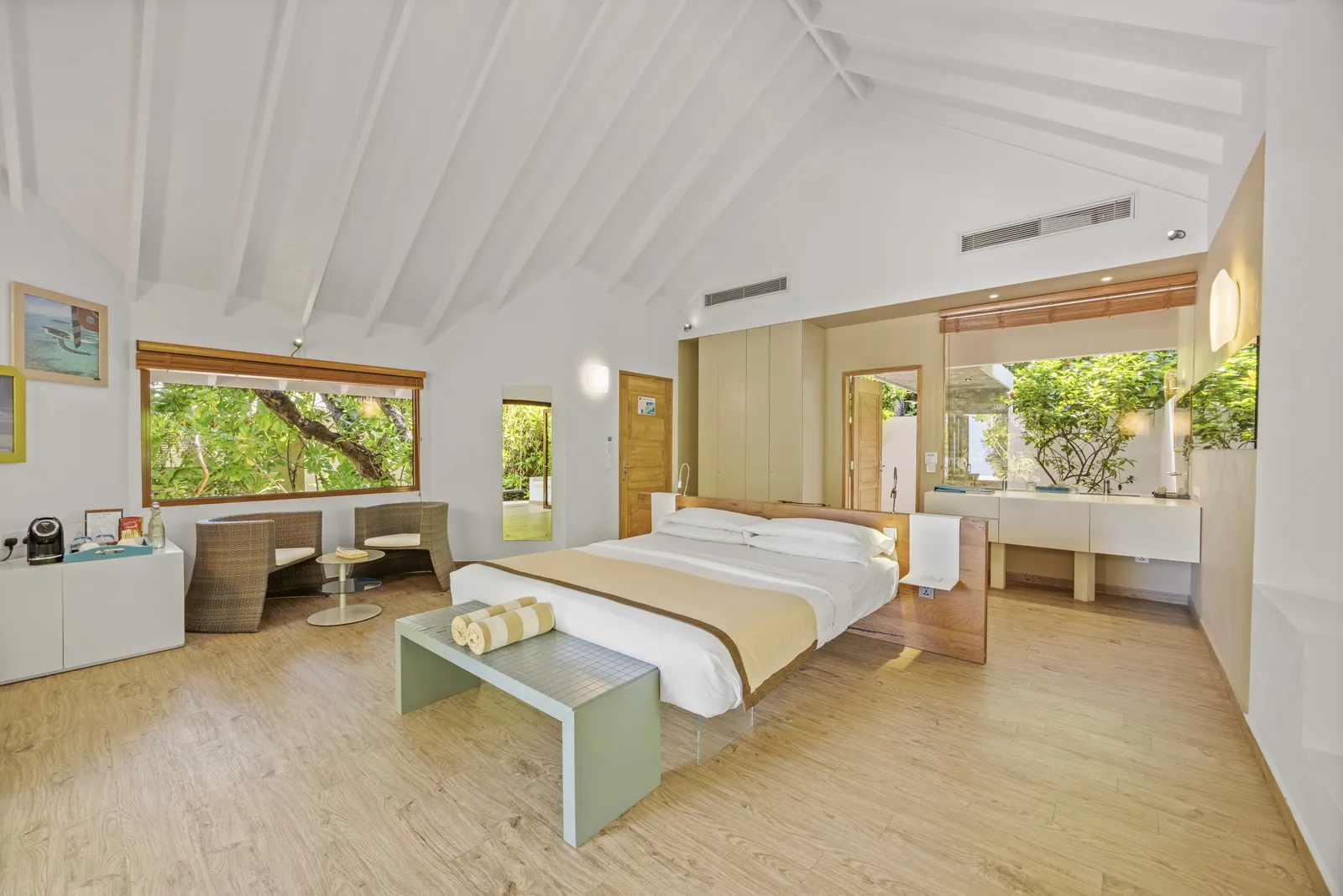 A Beach Suite bedroom, the bed in the middle and windows onto the garden