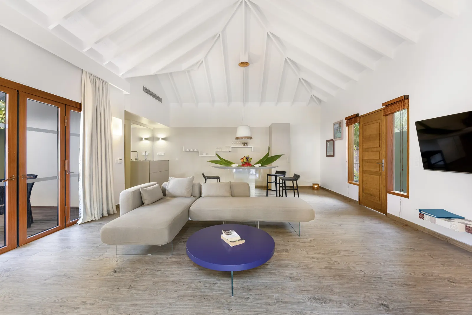 The Cocoon Suite living room, the pale sofa and blue table under the beamed roof